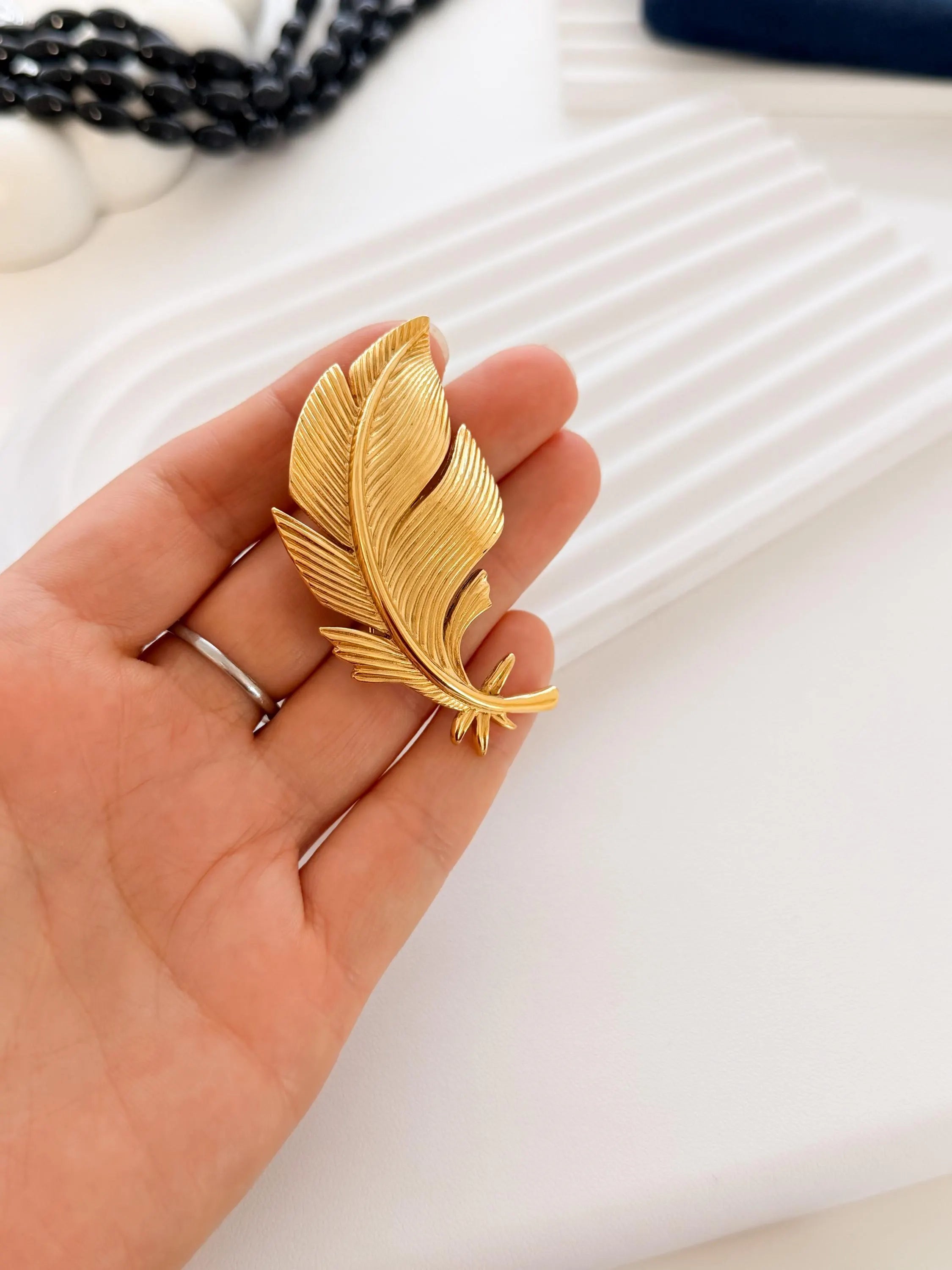 Dior gold leaf brooch side view sculptural refined design luxury jewelry
