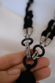 Detail of black oval beads, circular links and silver-tone metal accents on vintage YSL necklace