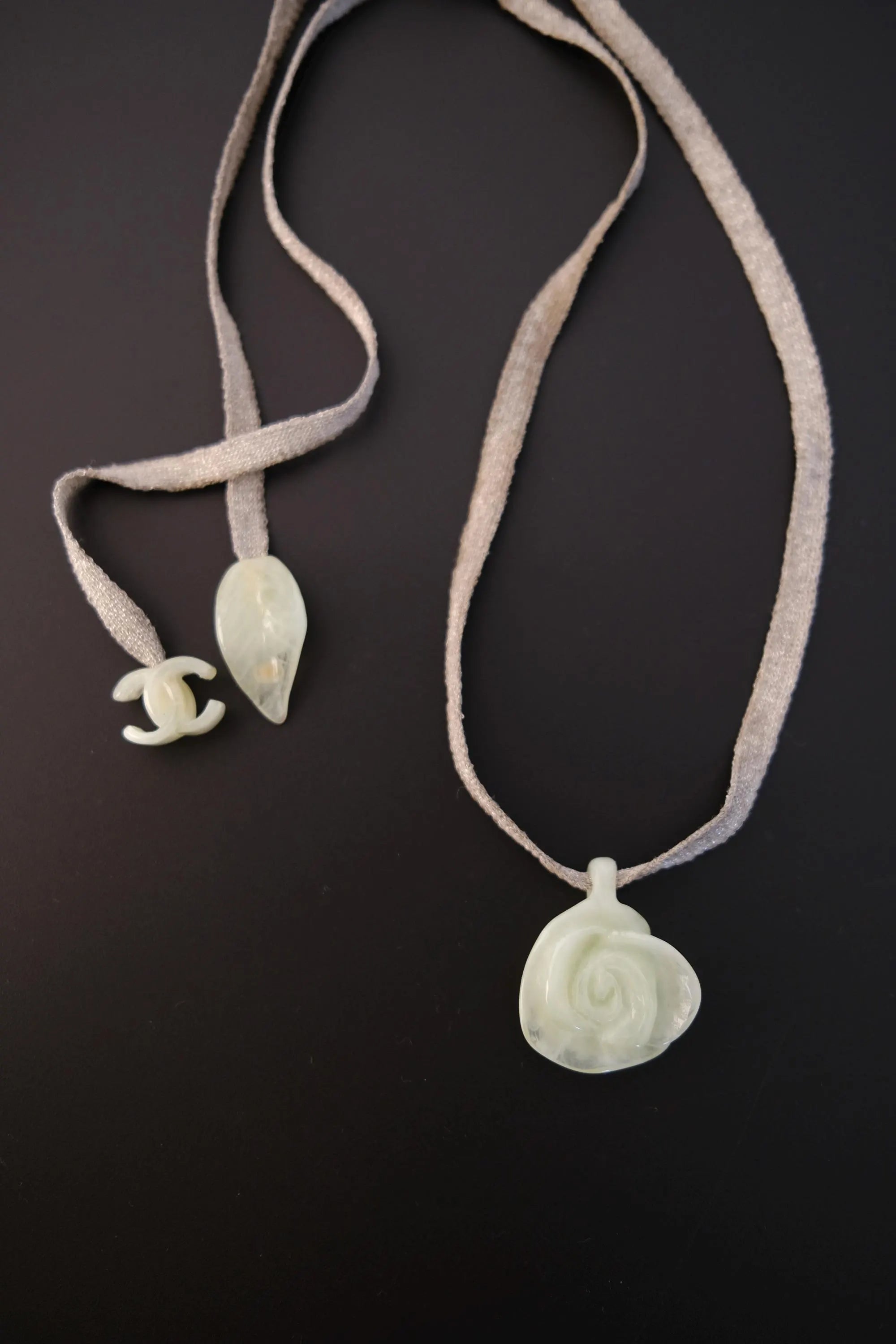 Full view of vintage CHANEL 82 cm textile ribbon necklace with translucent camellia pendant and CC charm
