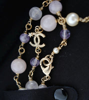 Close-up of CHANEL interlocking CC logo charms with small star details on vintage gold-tone necklace
