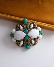 Vintage Christian Dior gold tone milk glass brooch styled on a blazer for an elegant classic look