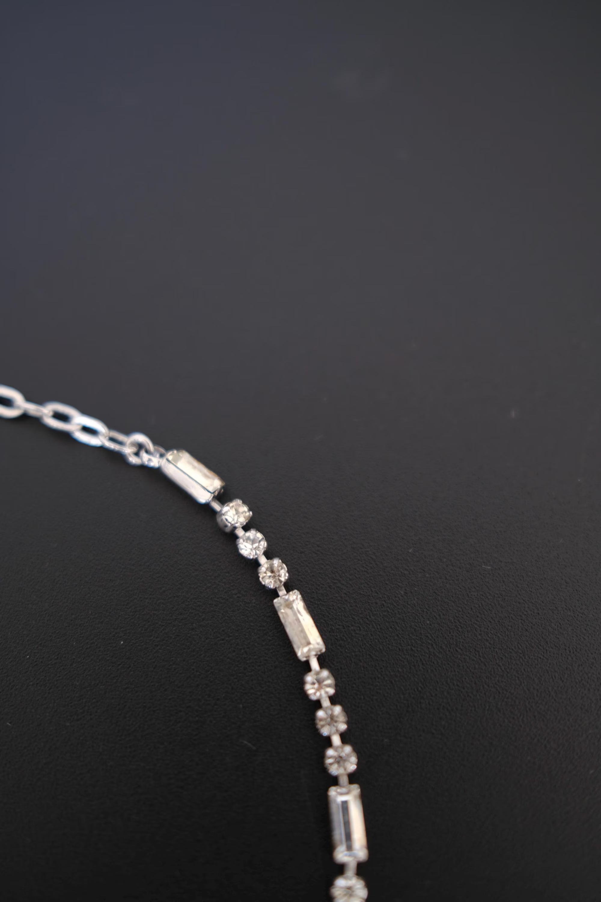 Detailed view of alternating round and rectangular crystal-set links on vintage Christian Dior silver-tone necklace