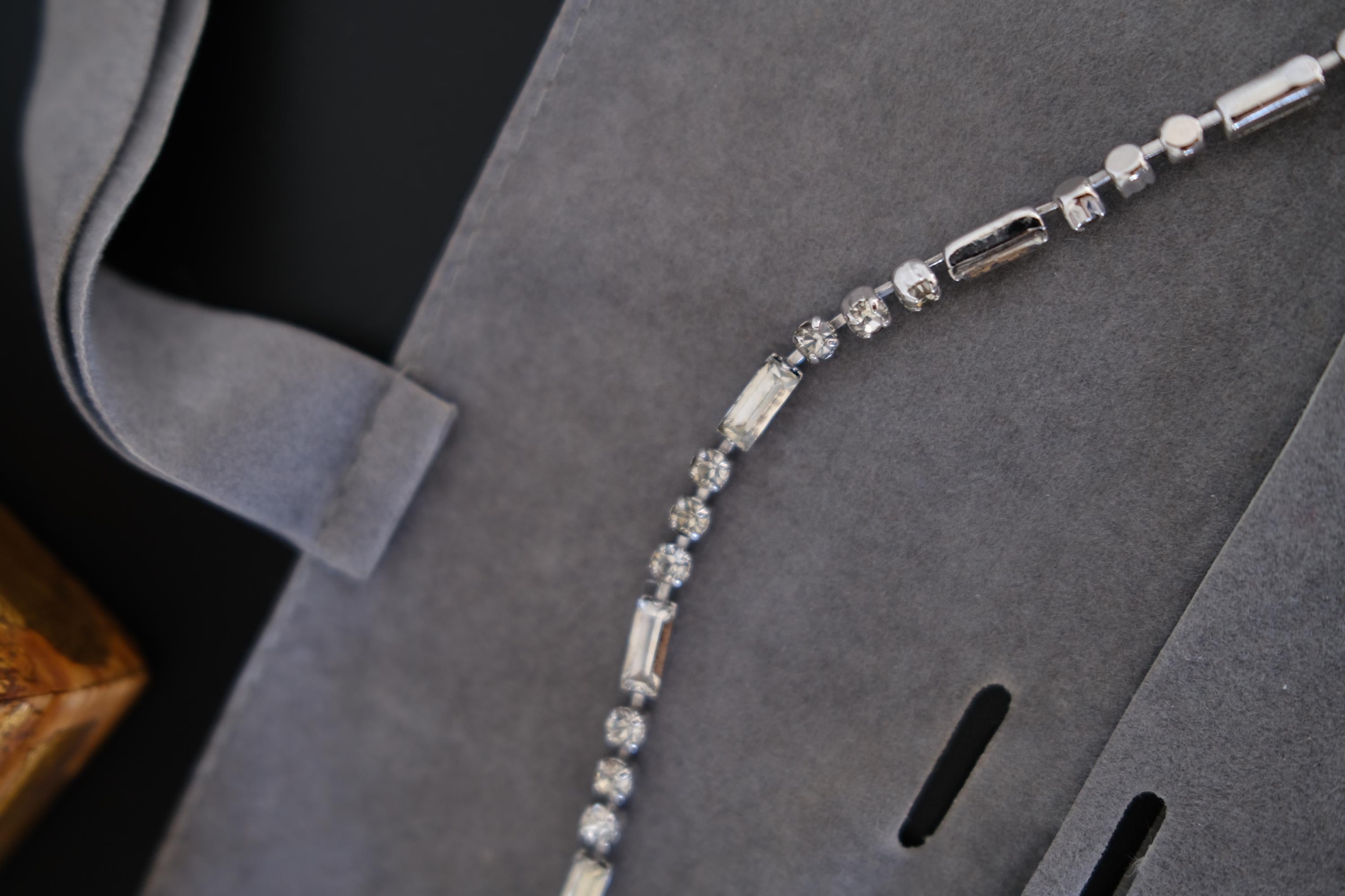 Detailed view of alternating round and rectangular crystal-set links on vintage Christian Dior silver-tone necklace