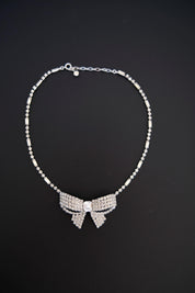 Full view of vintage Christian Dior crystal bow necklace featuring sparkling silver-tone rhinestone ribbon design and delicate crystal chain