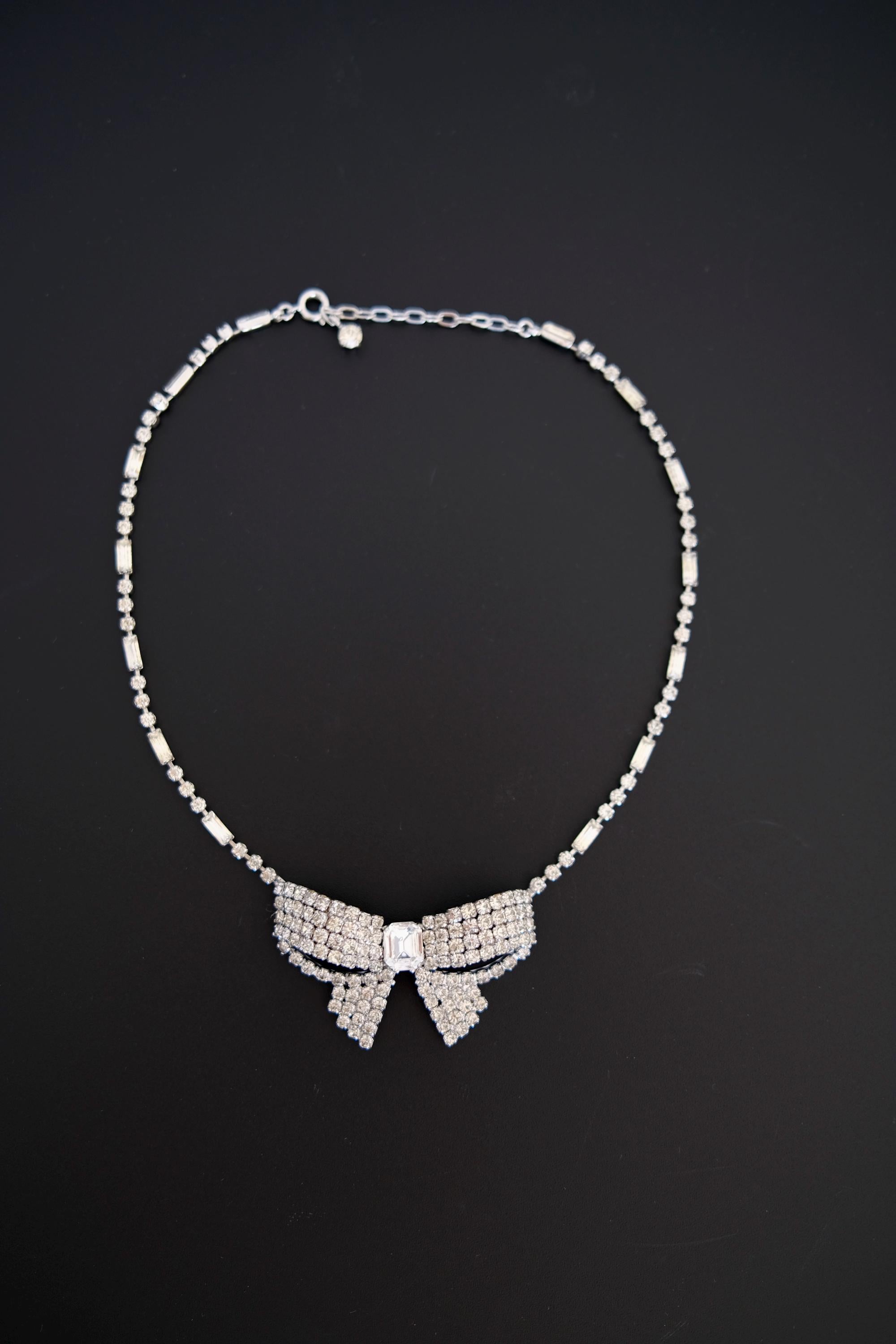 Full view of vintage Christian Dior crystal bow necklace featuring sparkling silver-tone rhinestone ribbon design and delicate crystal chain