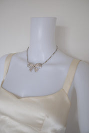 Vintage Christian Dior silver-tone crystal bow necklace styled with an evening dress for formal occasions
