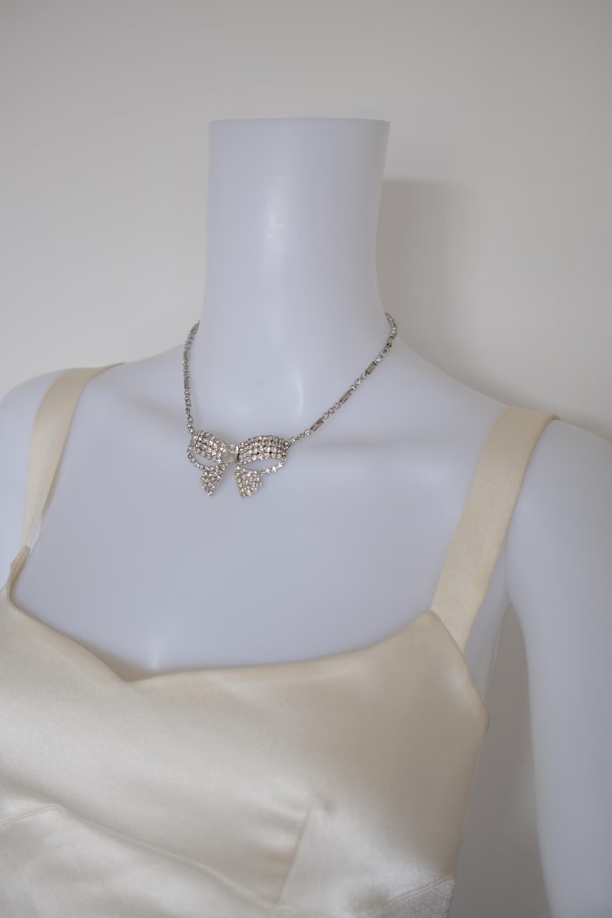 Vintage Christian Dior silver-tone crystal bow necklace styled with an evening dress for formal occasions