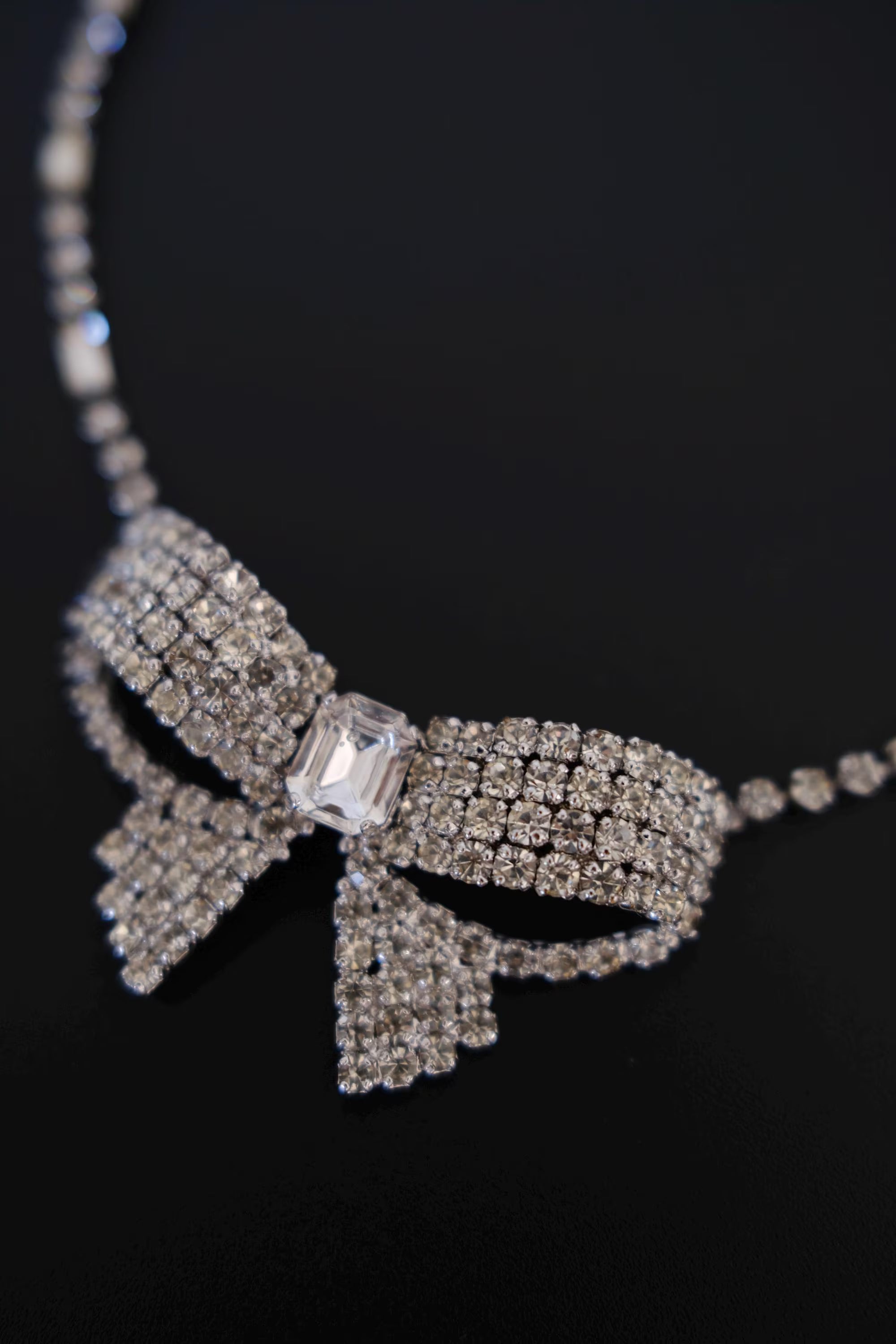 Macro detail of clear round and rectangular crystals on vintage Christian Dior Germany bow choker necklace