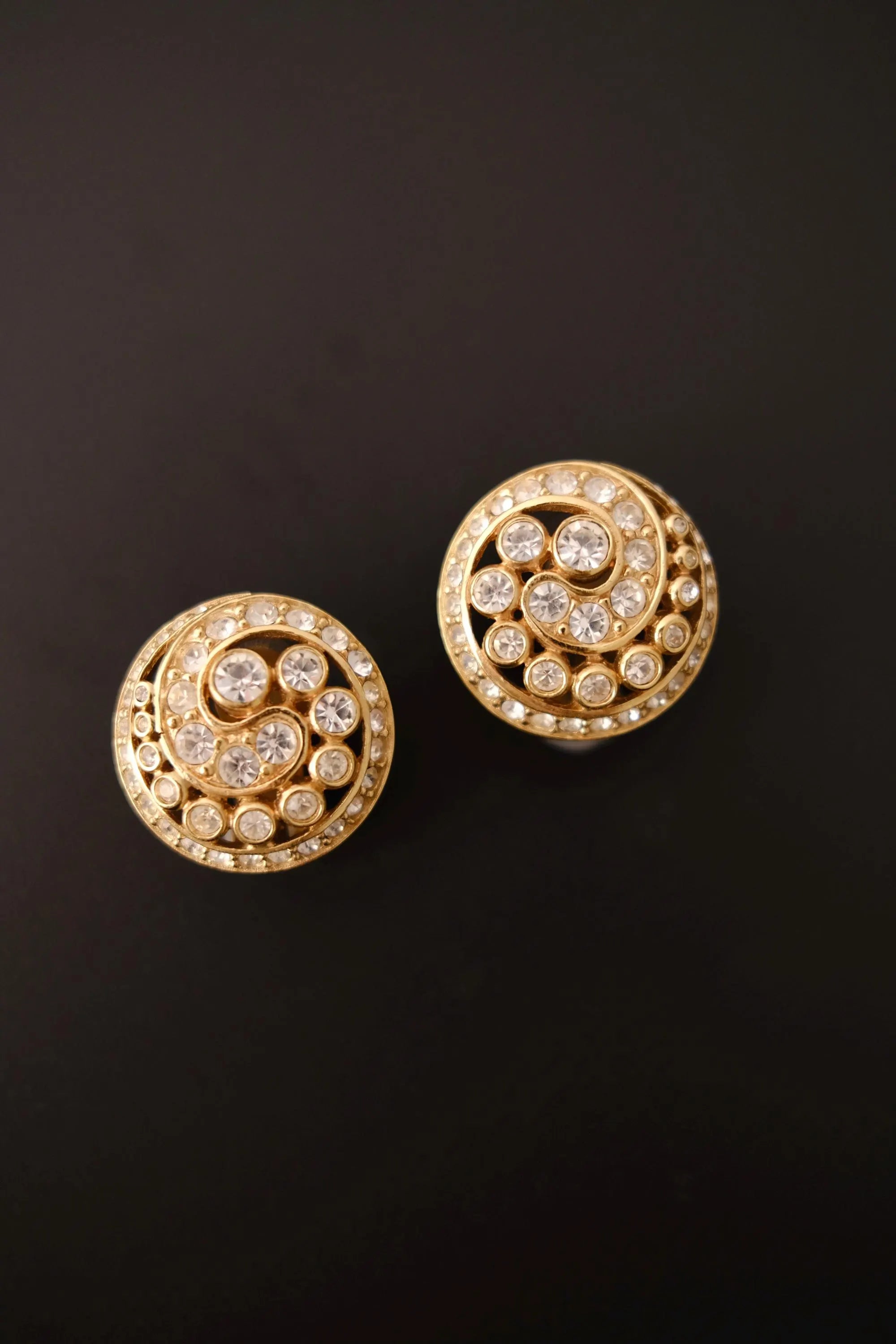 Vintage Christian Dior gold-tone clip-on earrings with sparkling clear crystals and dimensional spiral swirl design, made in Germany