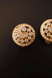 Detailed view of sparkling round-cut clear crystals set along gold-tone spiral curves of Christian Dior vintage earrings