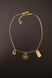 Full view of vintage Christian Dior gold tone chain necklace with three dangling signature Dior charms and adjustable extender