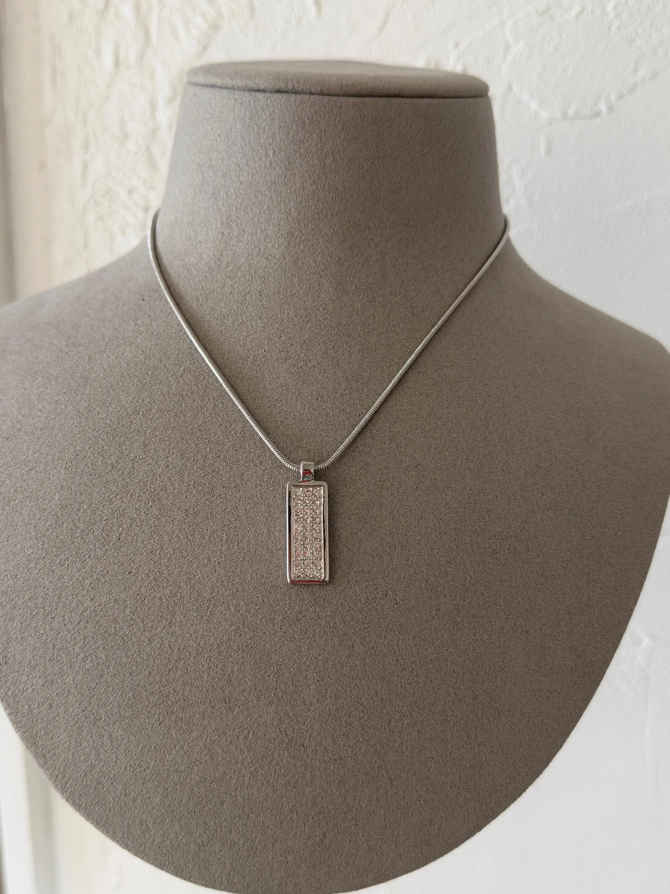 Vintage Christian Dior silver-tone rectangular monogram pendant necklace worn at the neckline