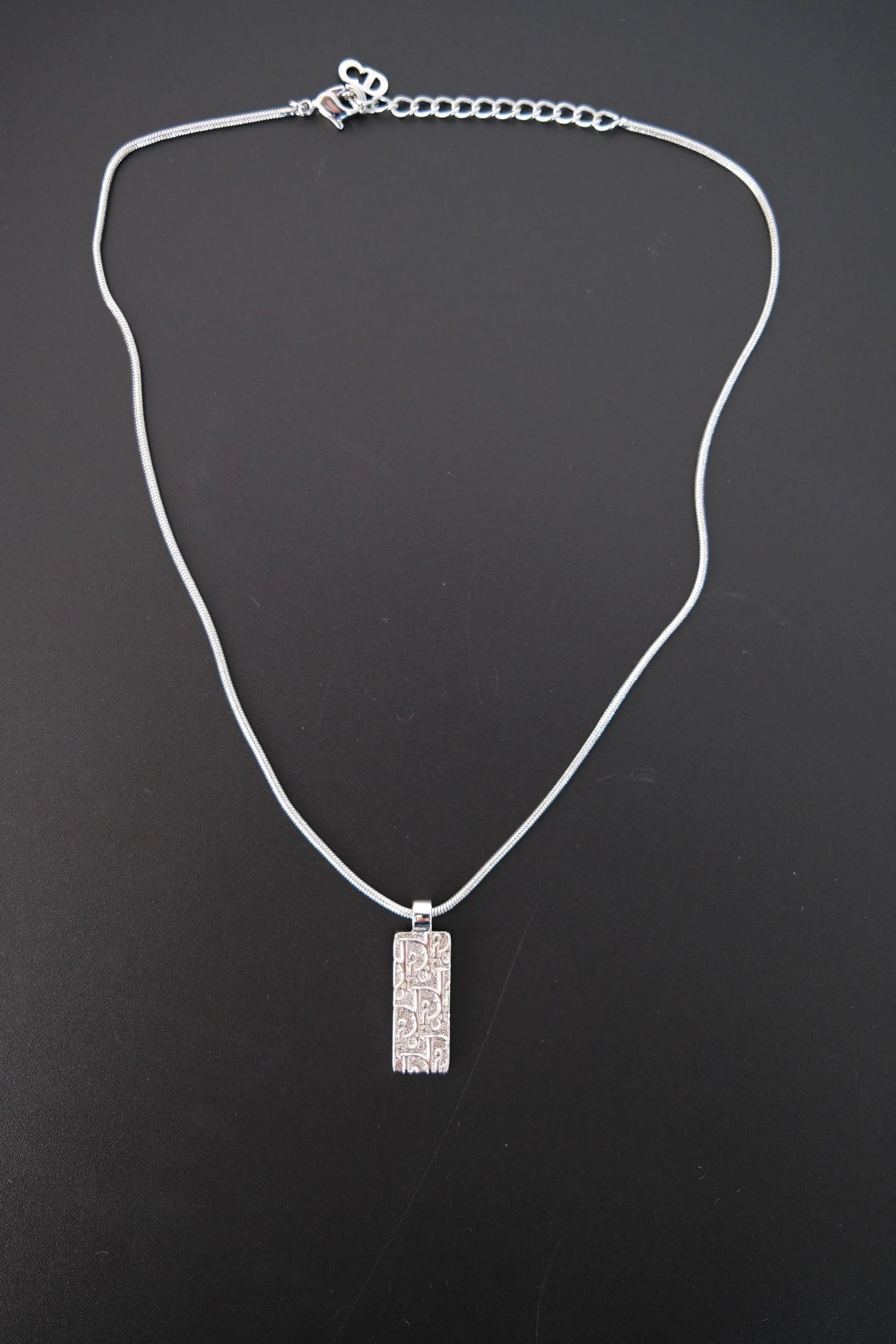 Full view of vintage Christian Dior reversible rectangular pendant necklace with silver-tone snake chain