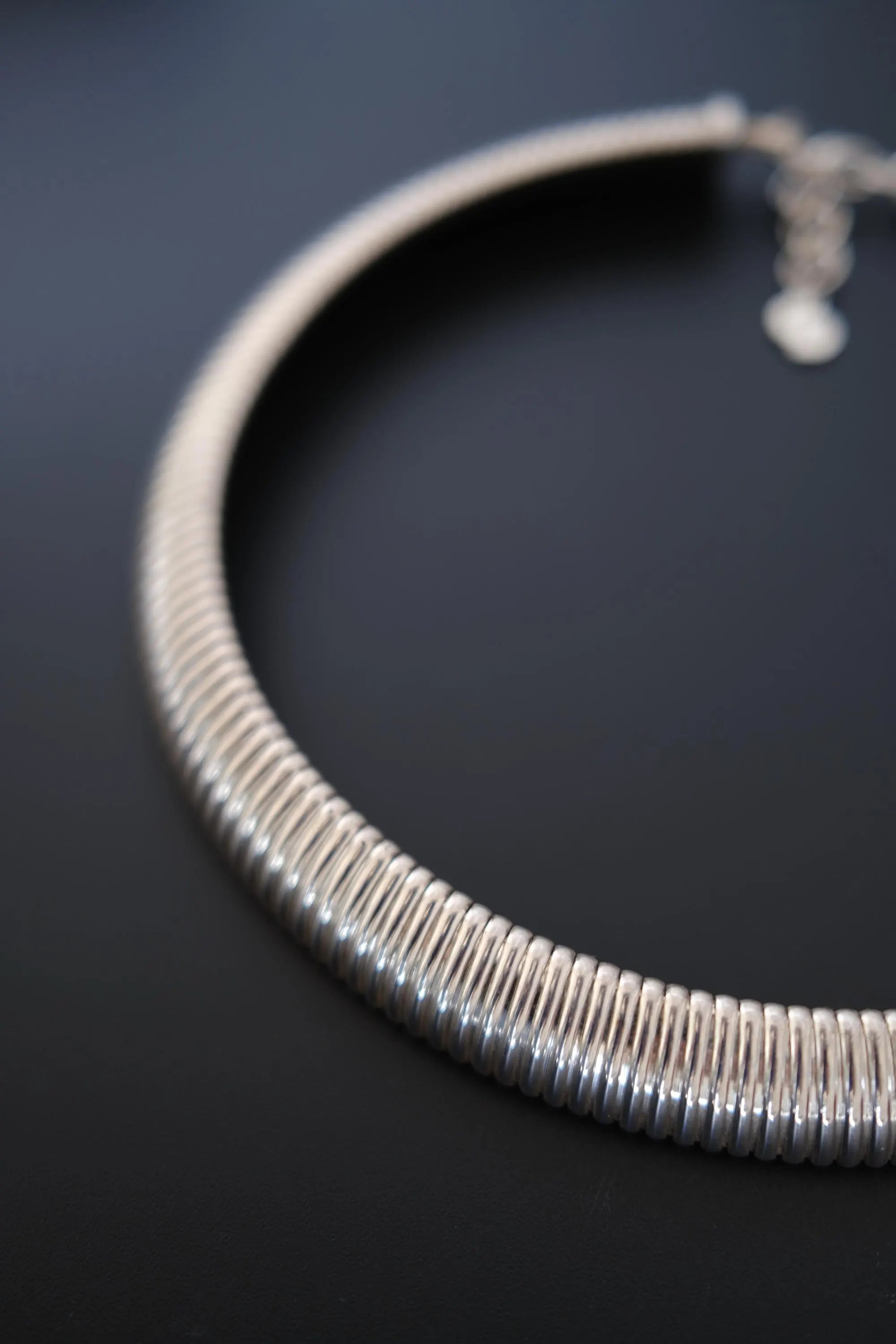Detailed view of flexible rounded gas pipe style links on Christian Dior vintage silver-tone collar necklace