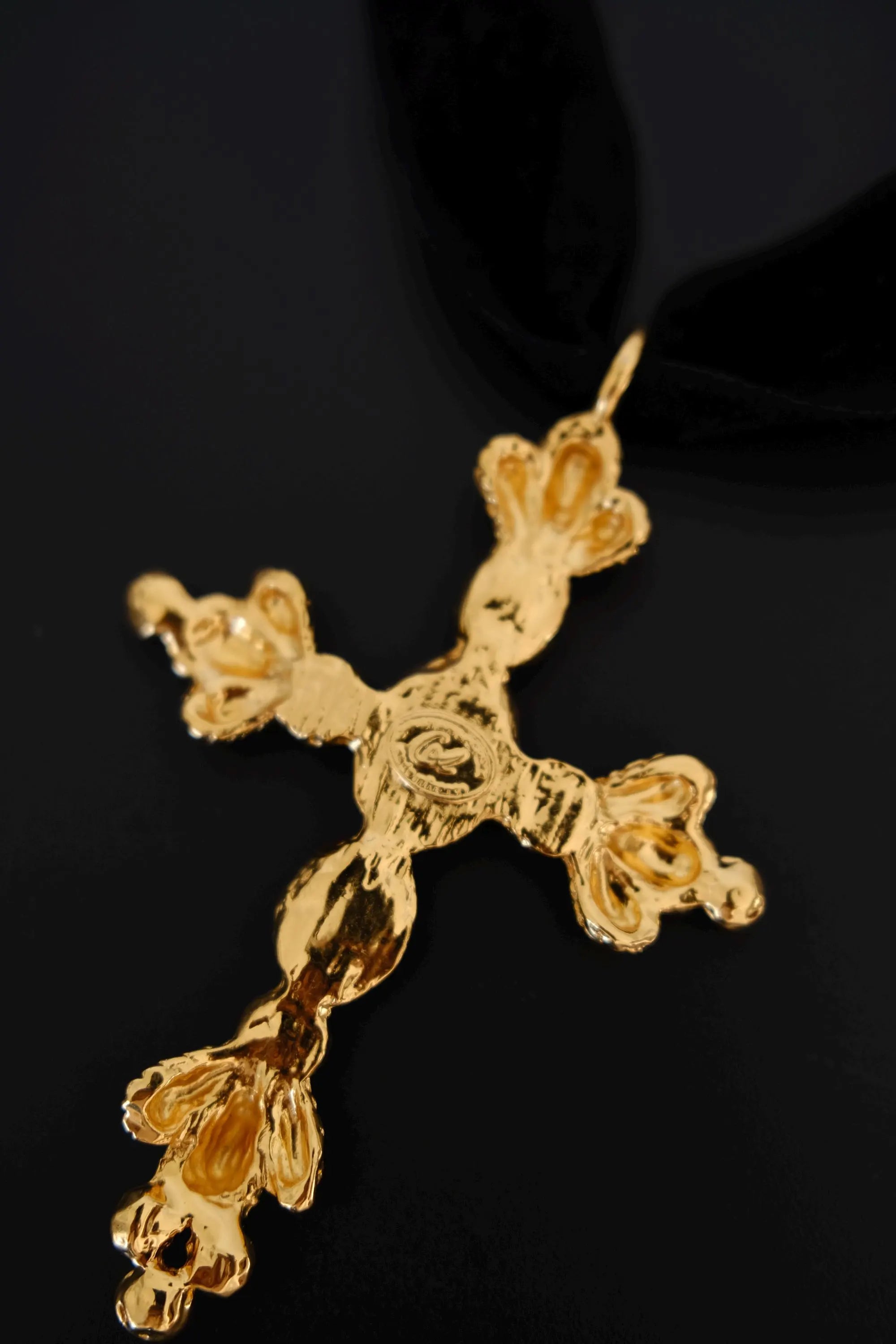 Close-up of Christian Lacroix signature marking on vintage gold-tone cross pendant necklace