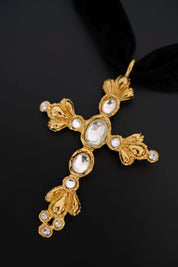 Detailed view of clear faceted crystals in various shapes set into the vintage Christian Lacroix gold-tone cross pendant