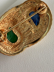 Close up Dior brooch gold setting with blue green cabochon and rhinestone detail