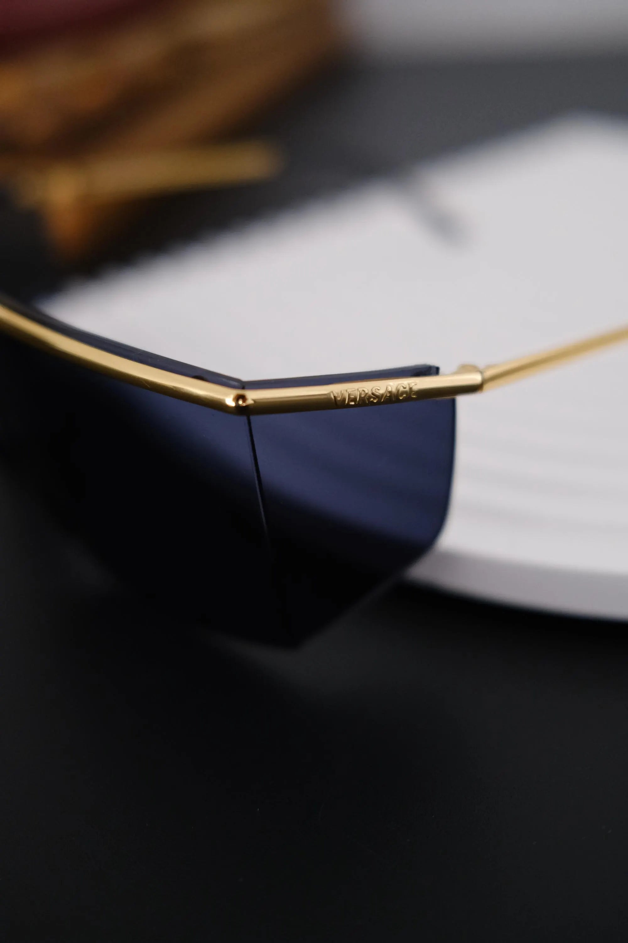 Close-up of polished gold tone metal brow bar on vintage Gianni Versace shield sunglasses