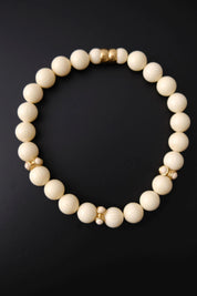 Full view of vintage Givenchy 46 cm graduated cream beaded choker with decorative gold-tone spacers