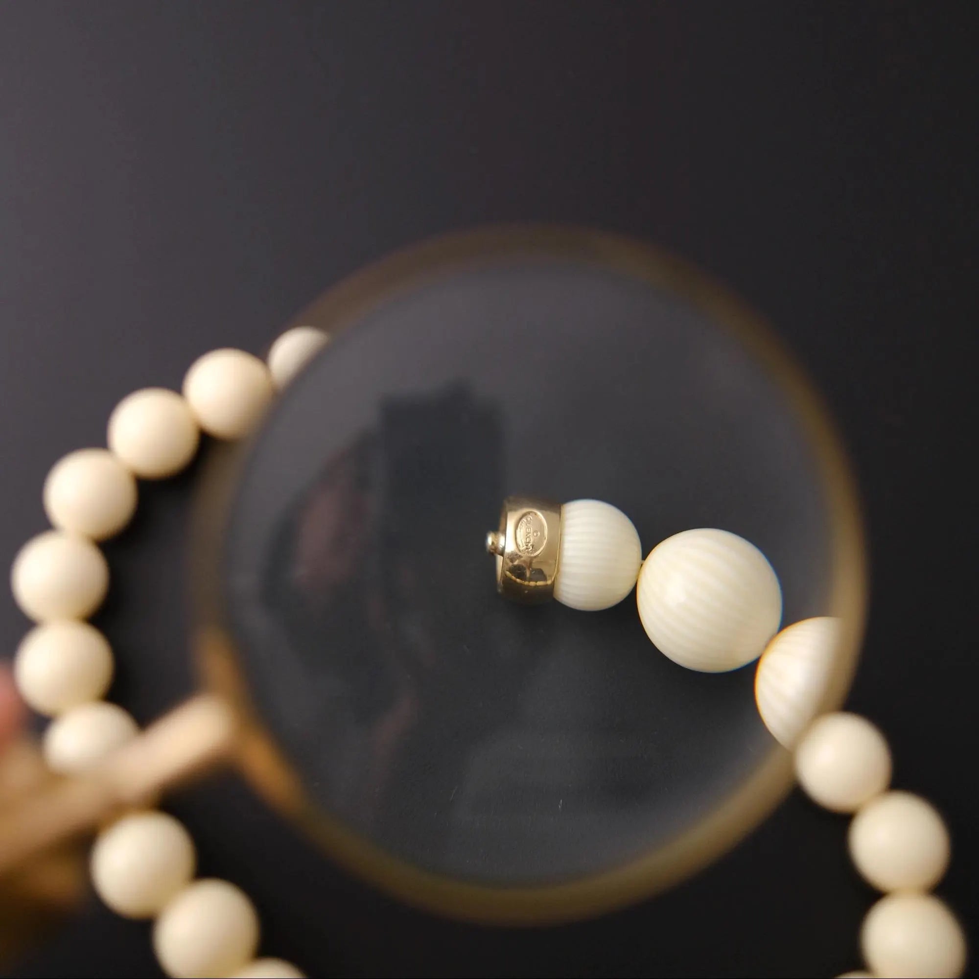 Gold-tone snap clasp closure on vintage Givenchy ivory beaded necklace