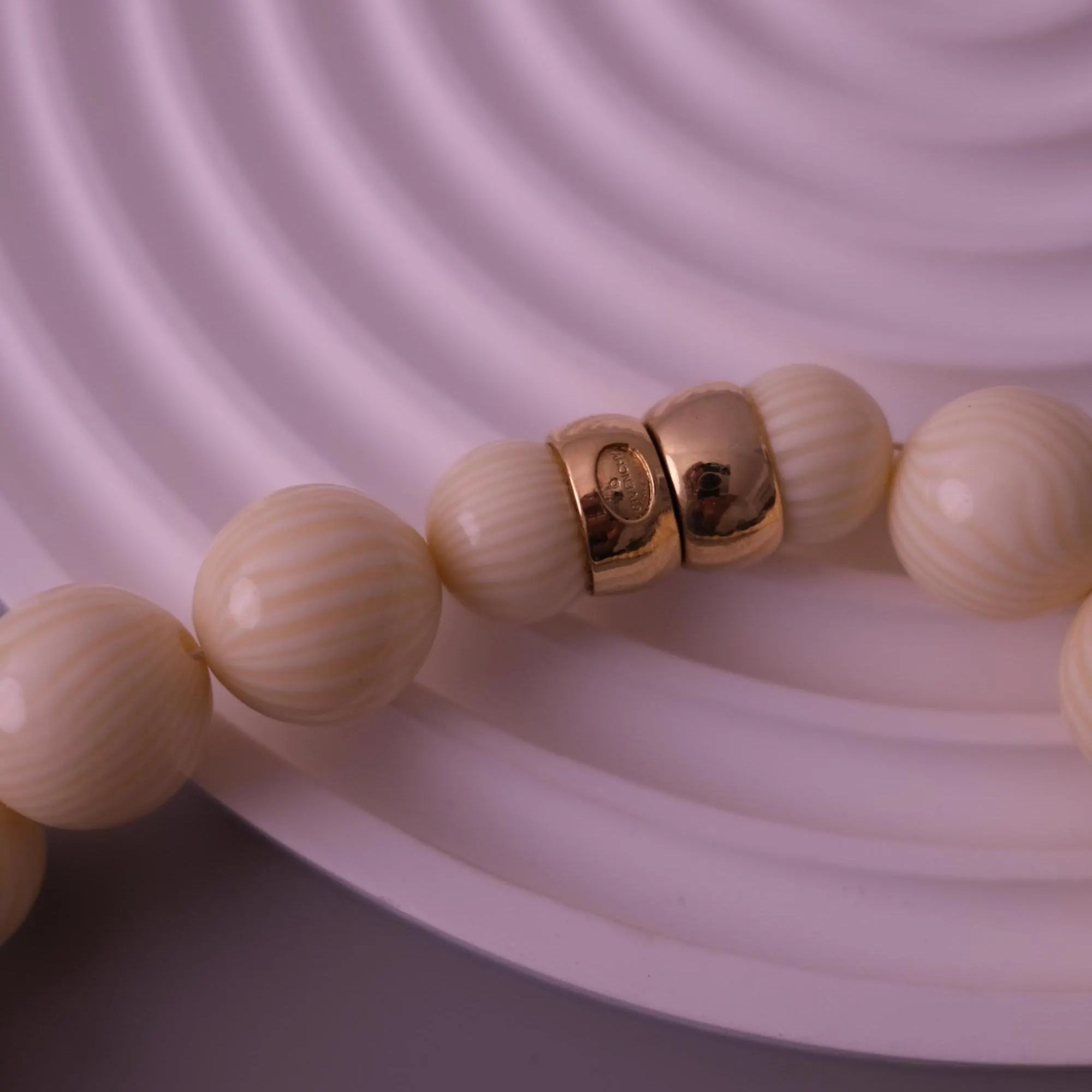 Gold-tone snap clasp closure on vintage Givenchy ivory beaded necklace