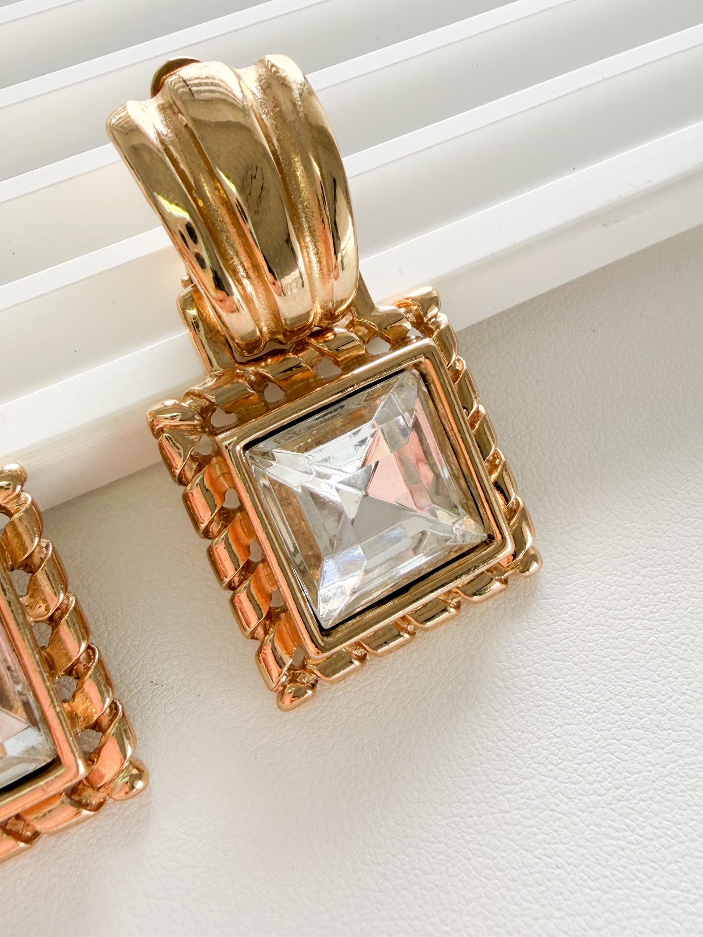 Close up Givenchy gold earrings faceted crystal detail sparkling luxury