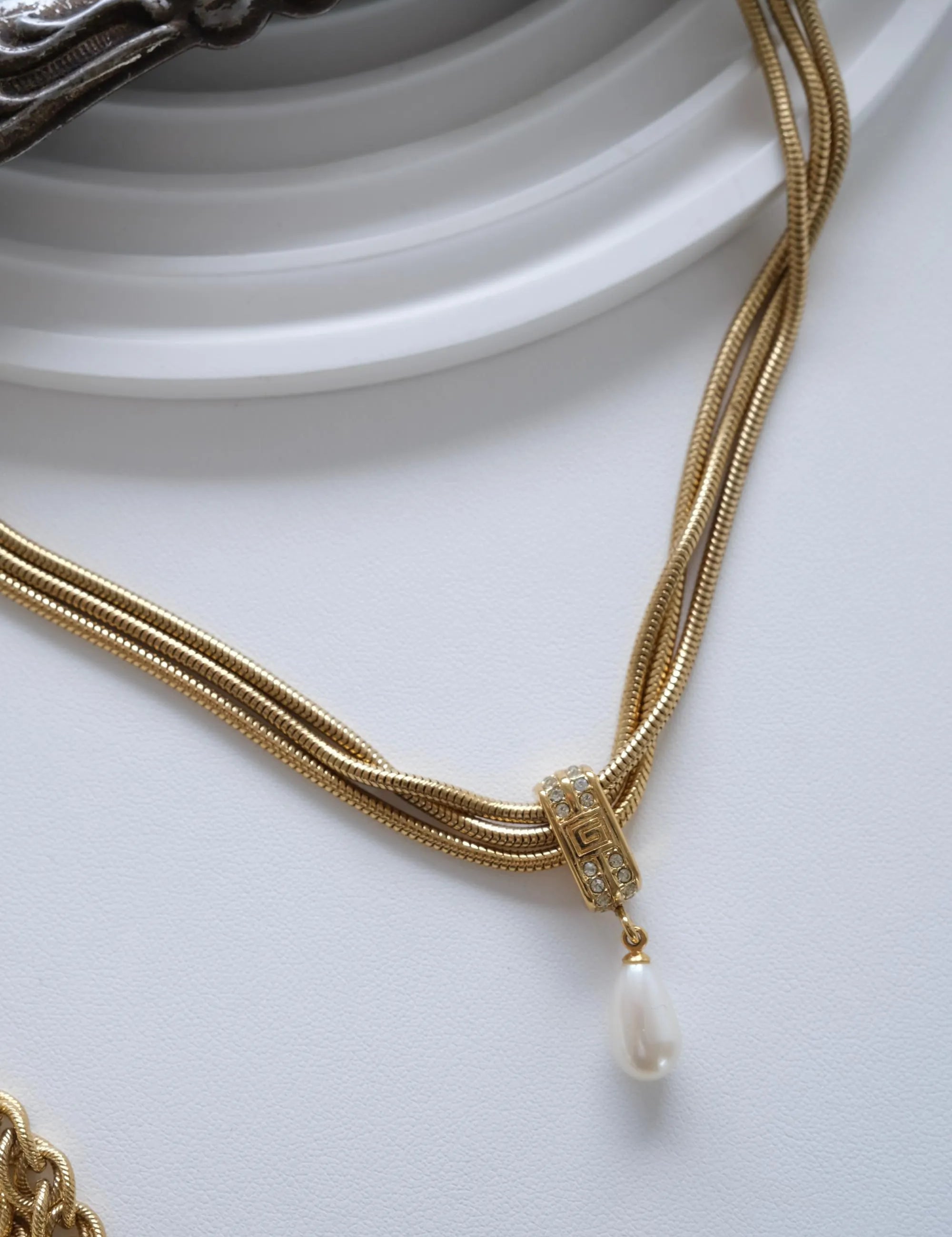 Close up of vintage Givenchy gold pendant with faux pearl drop detail
