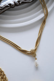 Close up of vintage Givenchy gold pendant with faux pearl drop detail