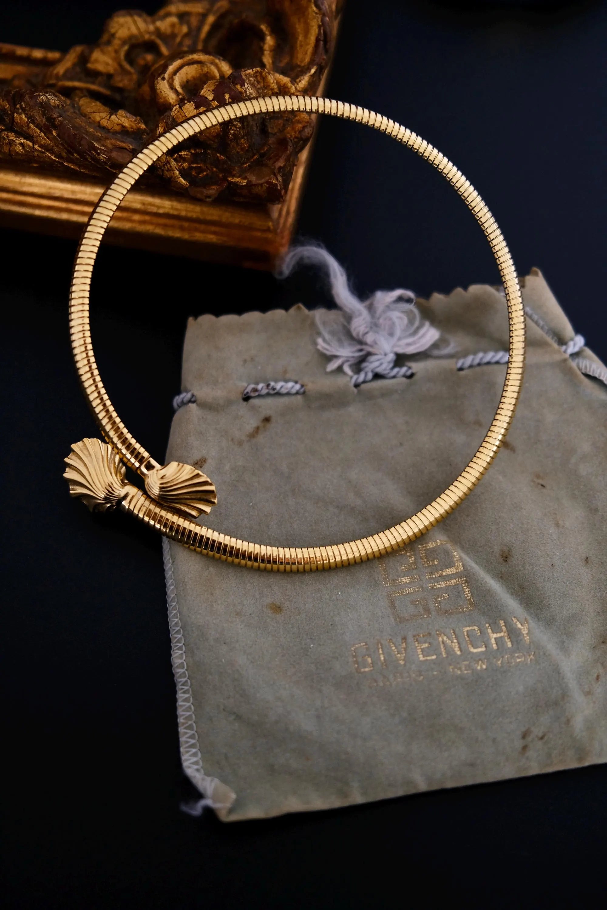 Full view of vintage Givenchy gold-tone articulated coil choker with two shell-shaped terminals