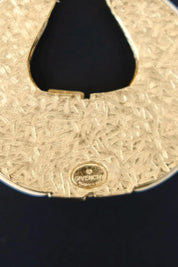 Close-up of GIVENCHY PARIS signature stamp on the textured gold tone back of vintage pendant necklace