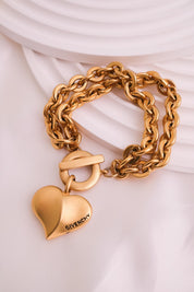 Vintage Givenchy Paris New York heart charm bracelet featuring a matte gold chunky chain, classic 1980s designer jewelry style, statement fashion accessory for women