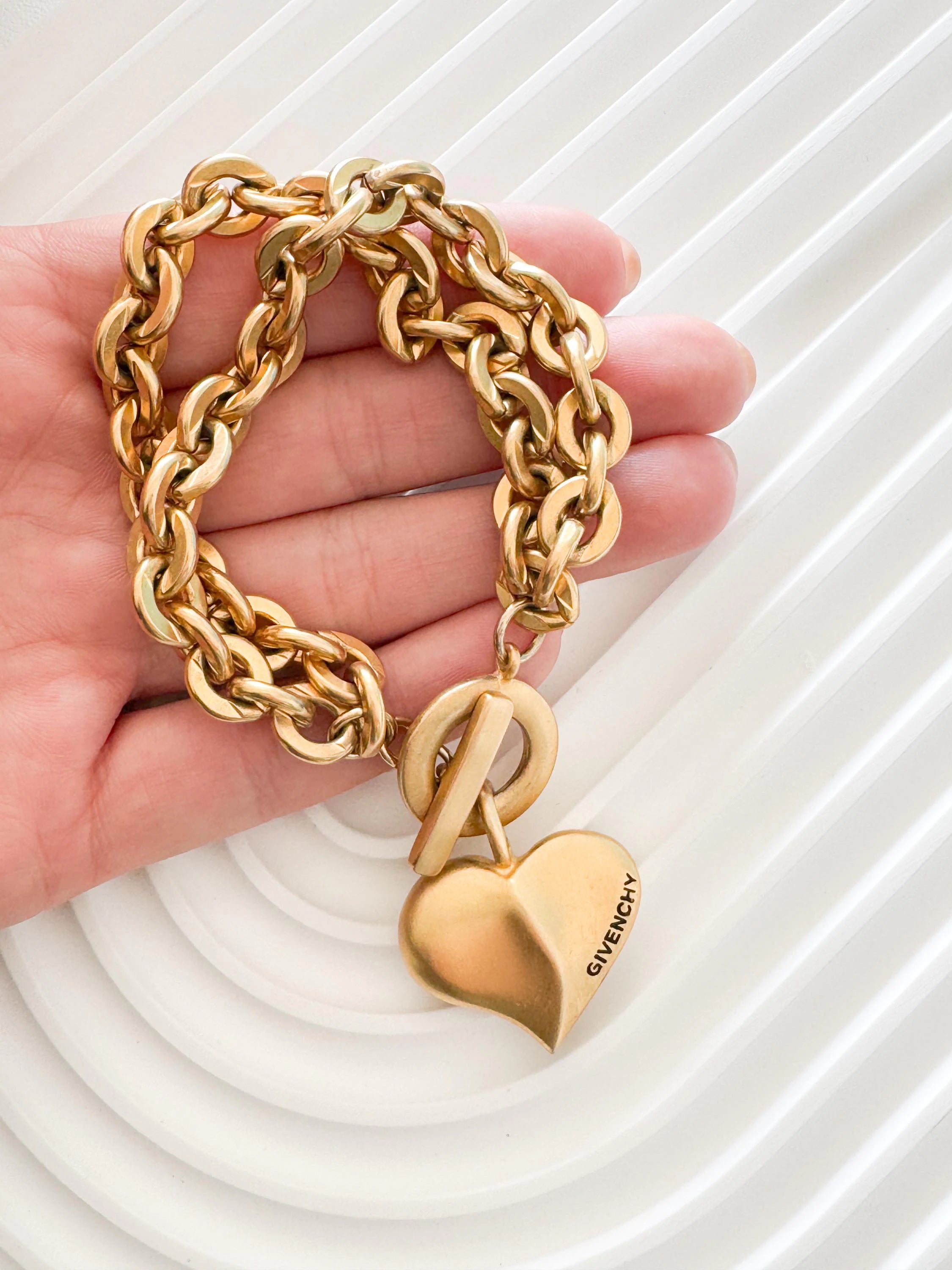 Vintage Givenchy Paris New York heart charm bracelet featuring a matte gold chunky chain, classic 1980s designer jewelry style, statement fashion accessory for women