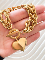Vintage Givenchy Paris New York heart charm bracelet featuring a matte gold chunky chain, classic 1980s designer jewelry style, statement fashion accessory for women