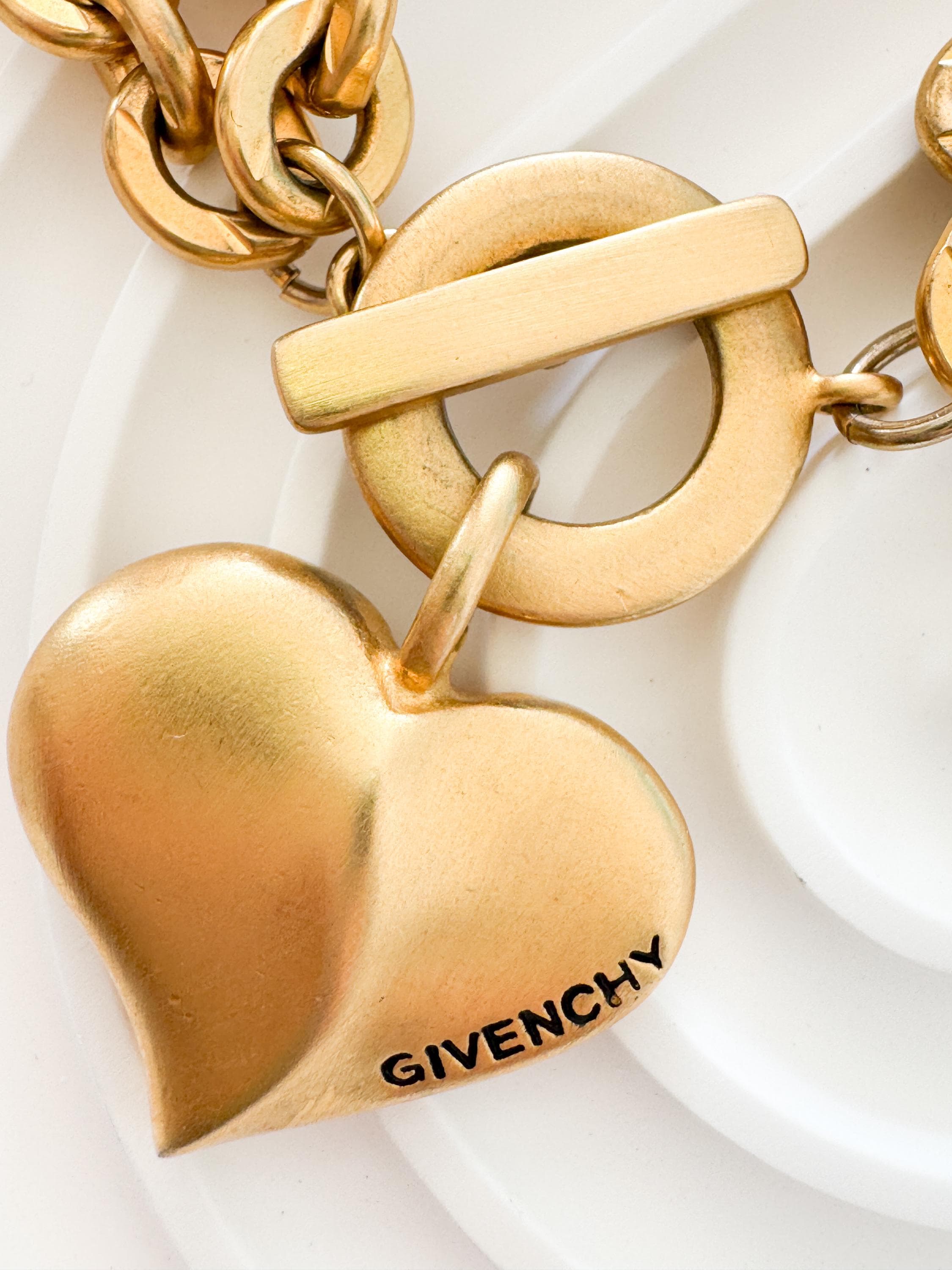Vintage Givenchy Paris New York heart charm bracelet featuring a matte gold chunky chain, classic 1980s designer jewelry style, statement fashion accessory for women
