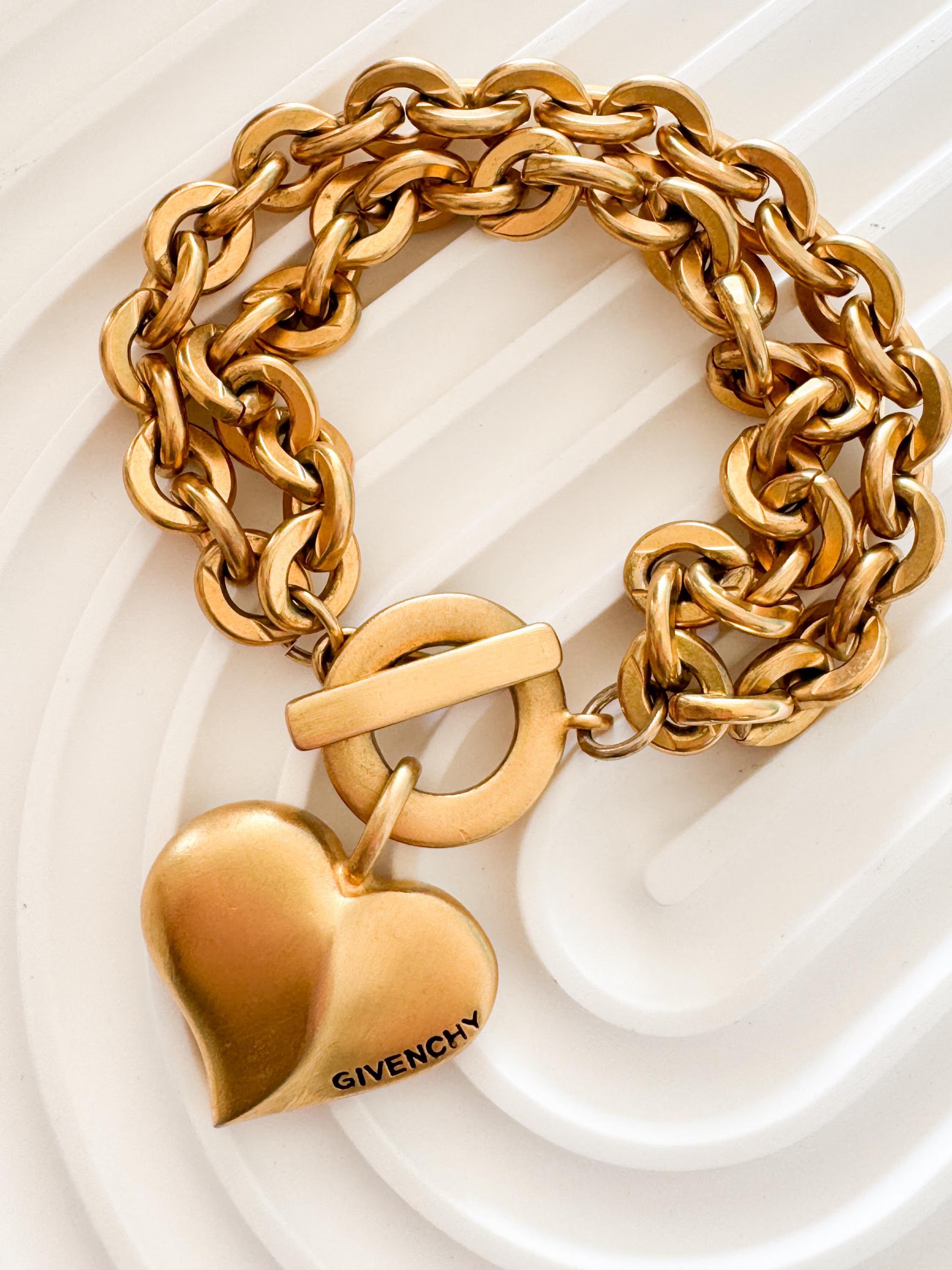 Vintage Givenchy Paris New York heart charm bracelet featuring a matte gold chunky chain, classic 1980s designer jewelry style, statement fashion accessory for women