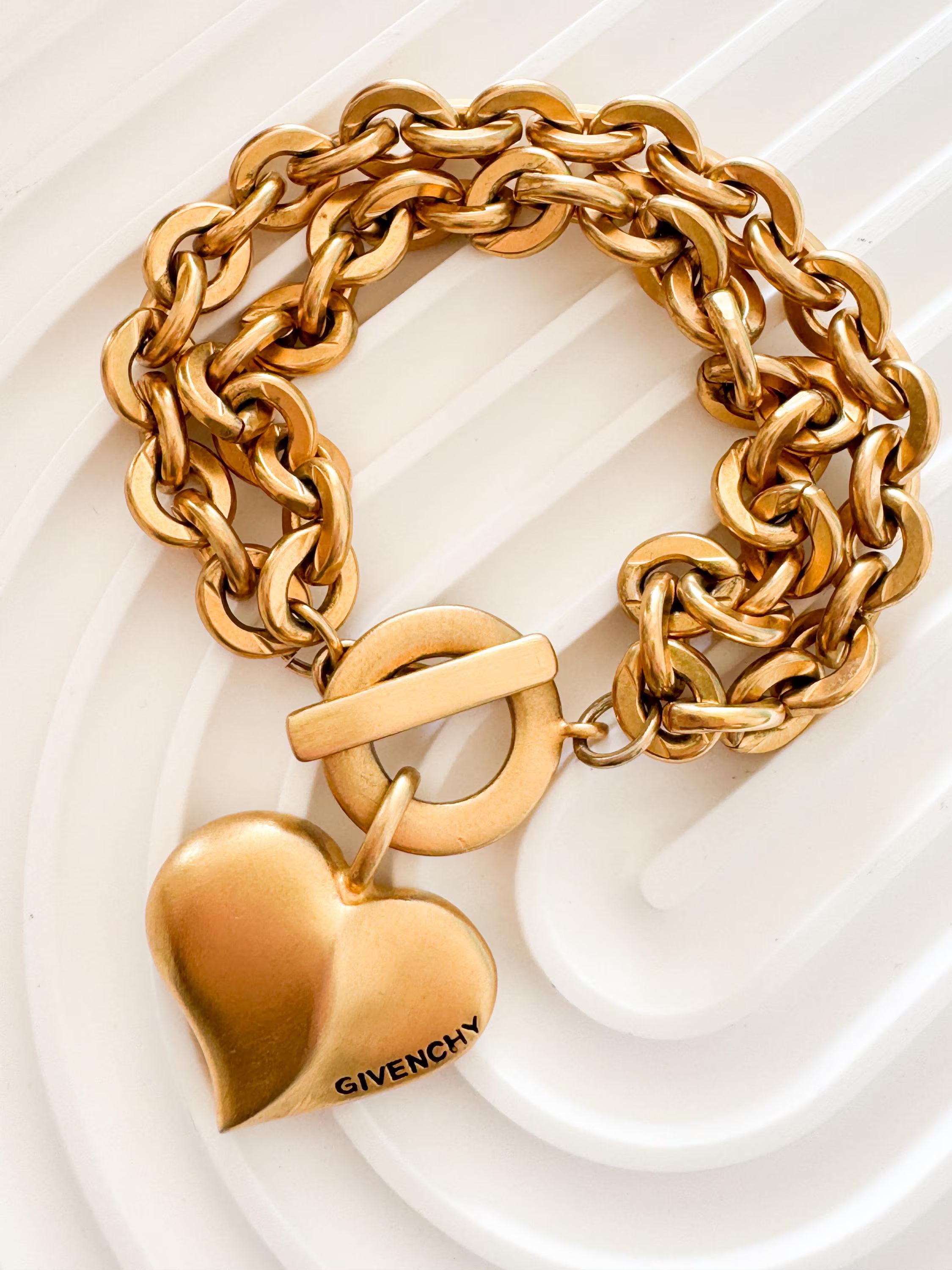 Vintage Givenchy Paris New York heart charm bracelet featuring a matte gold chunky chain, classic 1980s designer jewelry style, statement fashion accessory for women