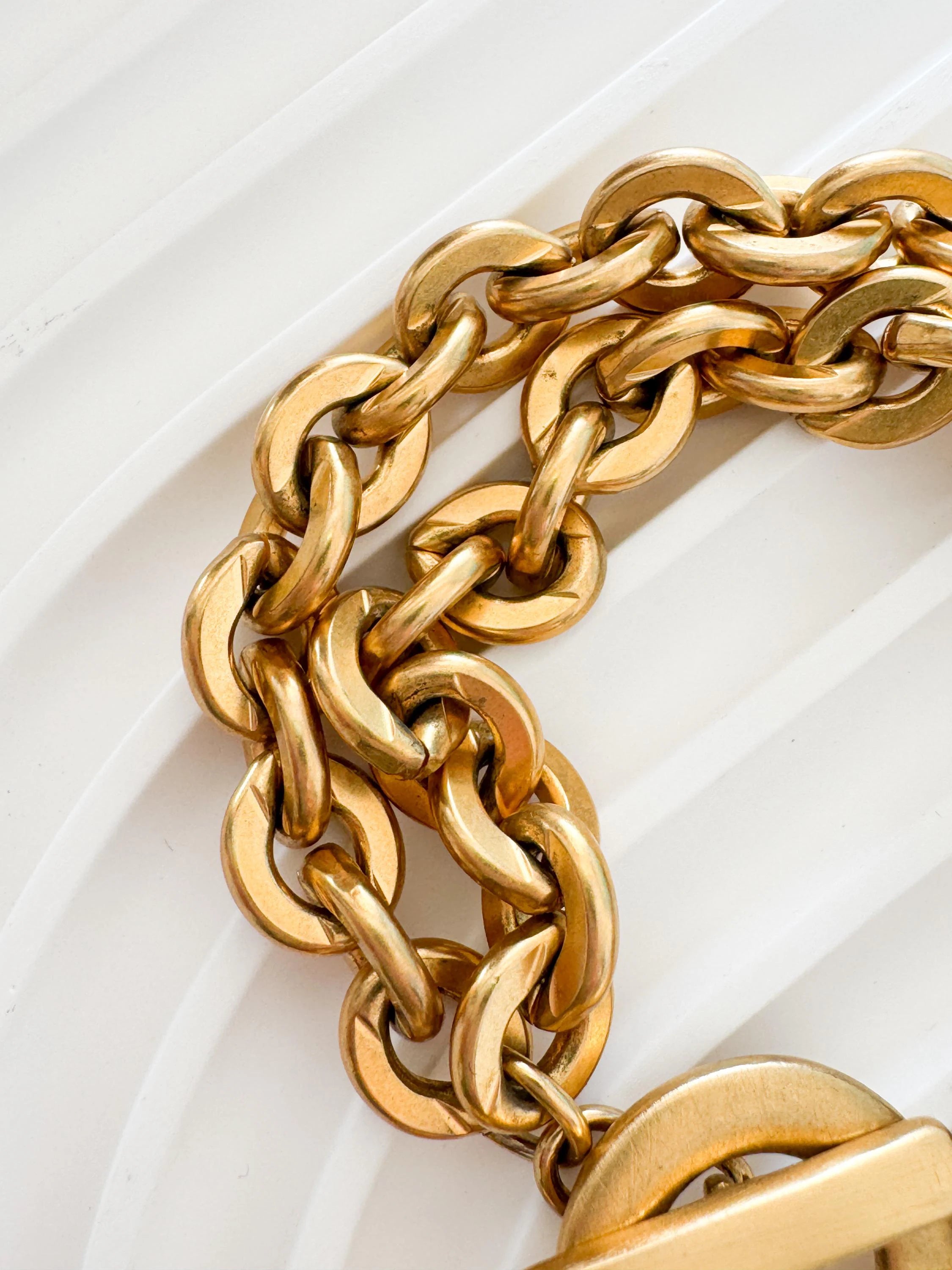 Vintage Givenchy Paris New York heart charm bracelet featuring a matte gold chunky chain, classic 1980s designer jewelry style, statement fashion accessory for women