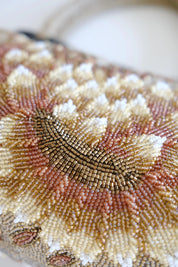 Macro detail of intricate Japanese bead embroidery showing layered floral patterns and textured ivory gold beadwork