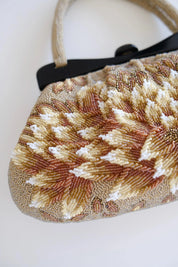 Macro detail of intricate Japanese bead embroidery showing layered floral patterns and textured ivory gold beadwork