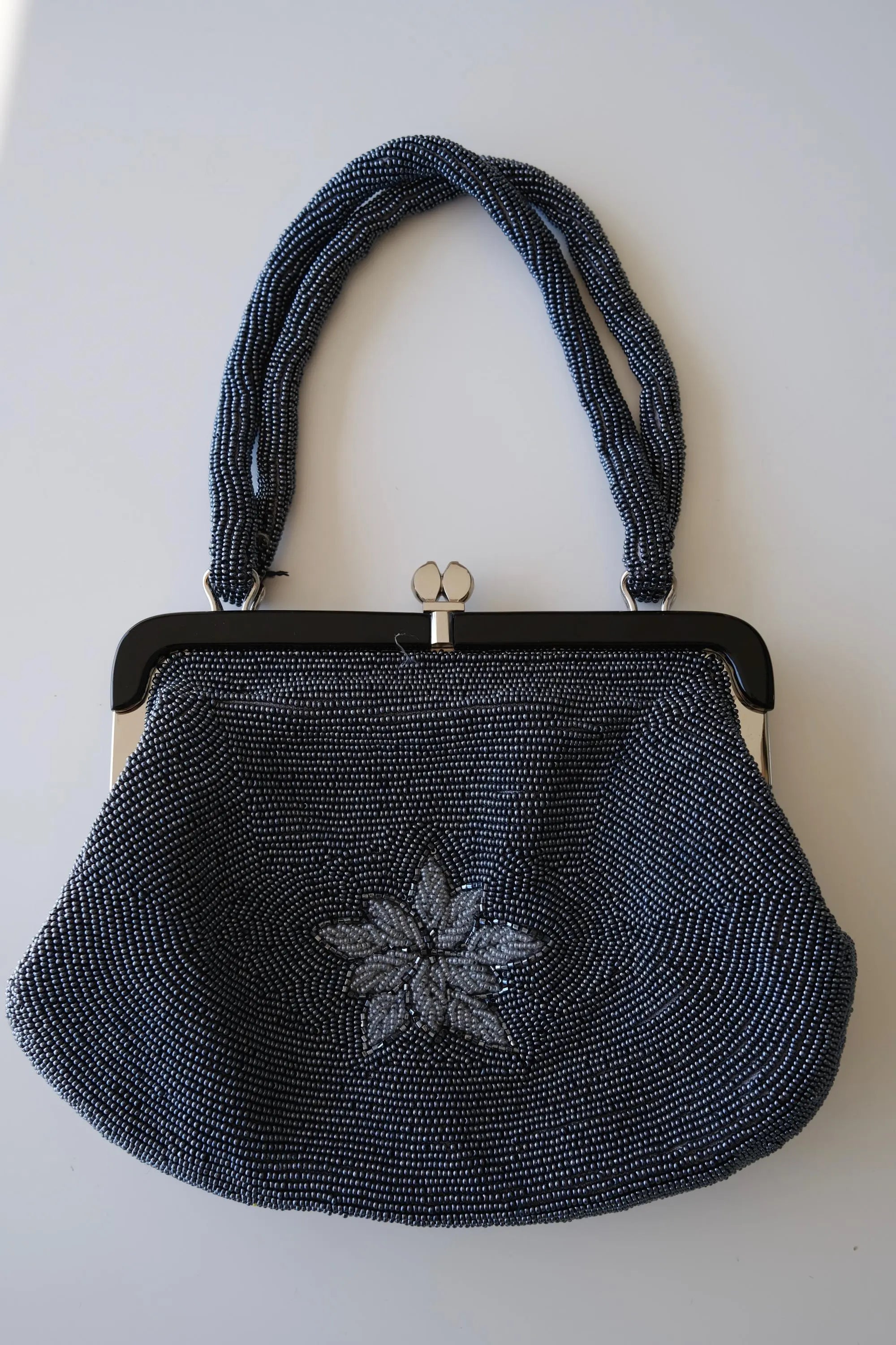 Close-up of dimensional leaf motifs surrounding the large peony flower on vintage Japanese glass beaded handbag