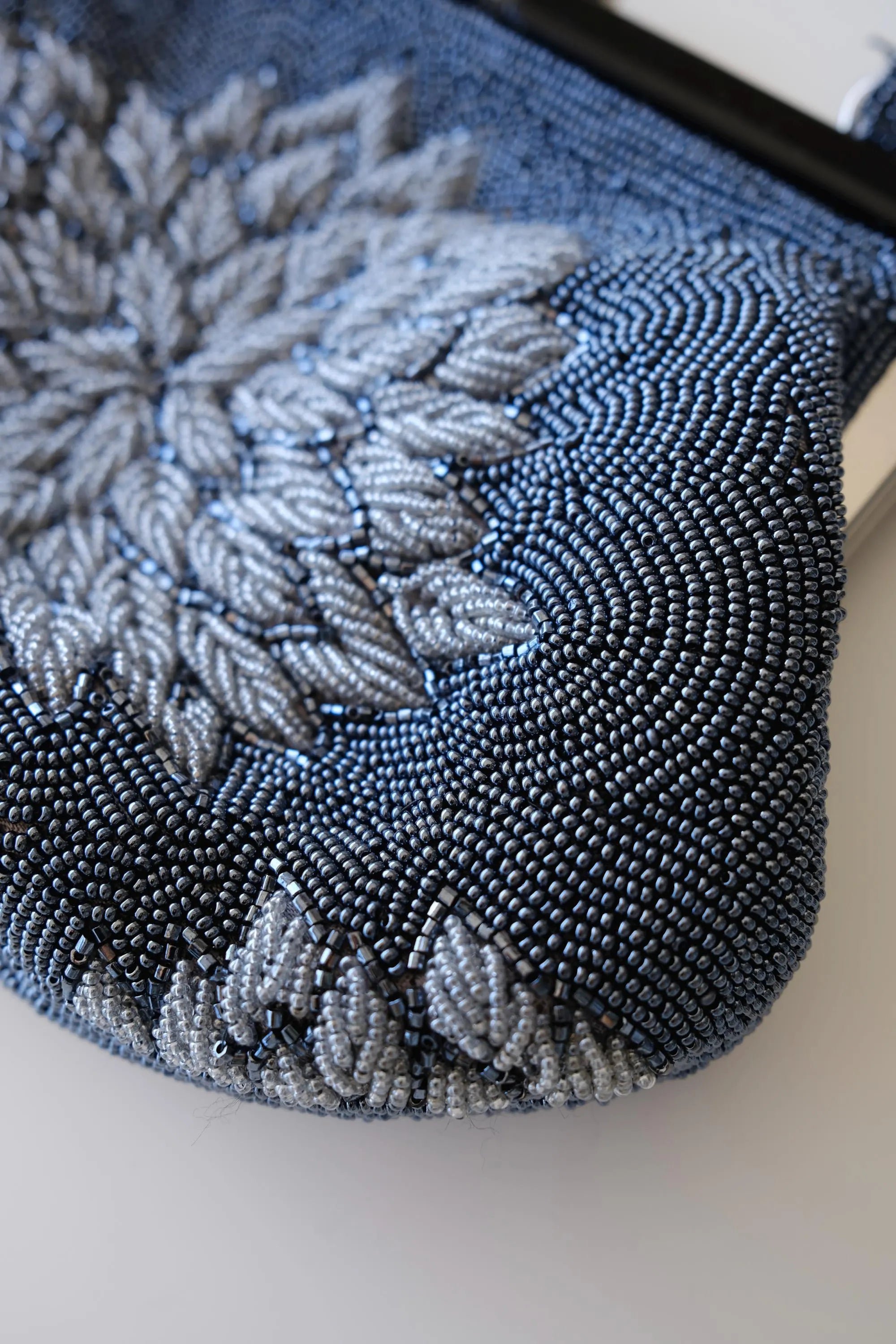 Detailed view of layered dimensional peony petals in silver-grey glass beads on vintage Japanese evening handbag