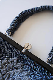 Close-up of decorative kiss-lock clasp on vintage Japanese blue and silver floral beaded evening bag