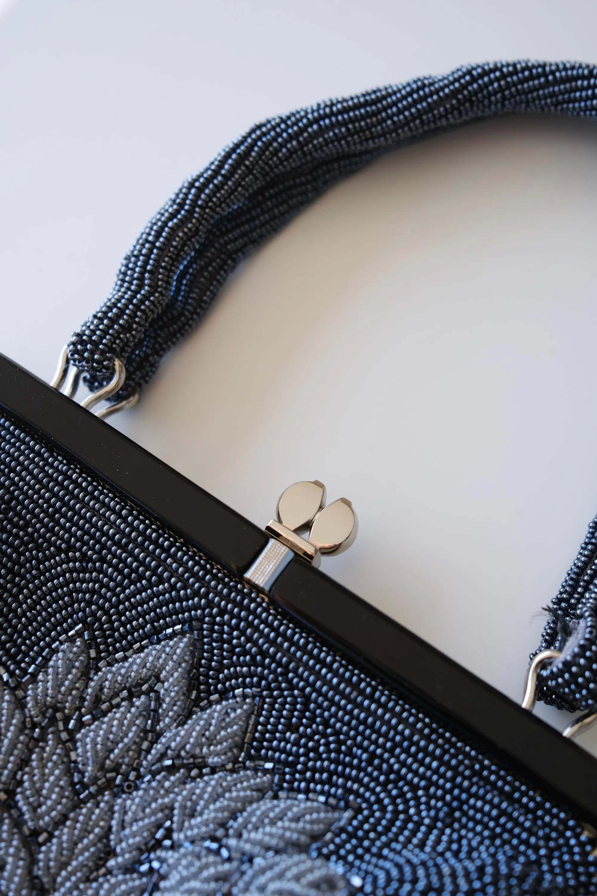 Close-up of decorative kiss-lock clasp on vintage Japanese blue and silver floral beaded evening bag