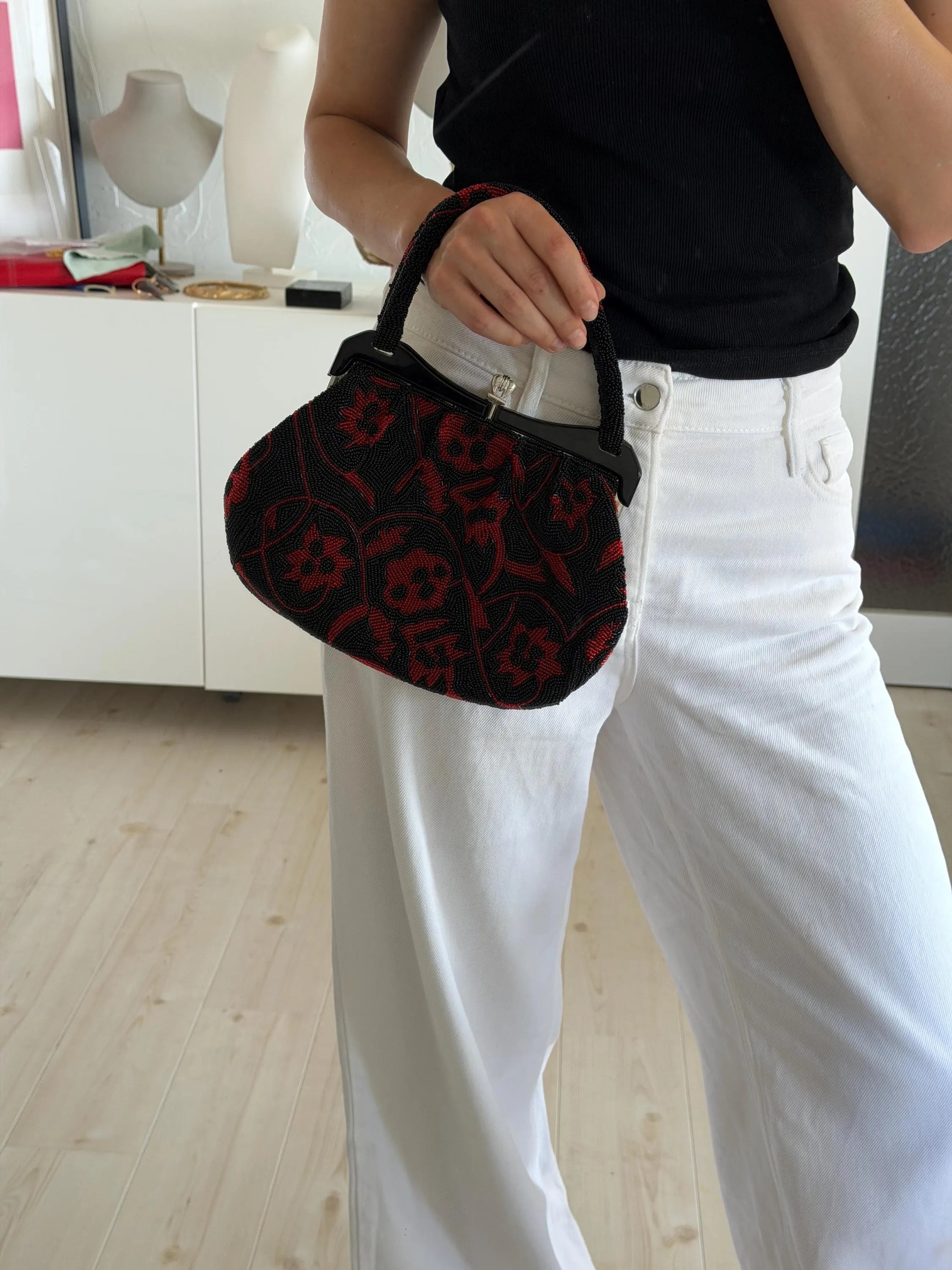 Vintage Japanese black and red floral beaded evening handbag carried by hand with structured beaded top handle