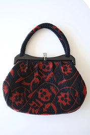 Front view of vintage Japanese black and red glass seed bead handbag featuring intricate floral and scrolling vine embroidery