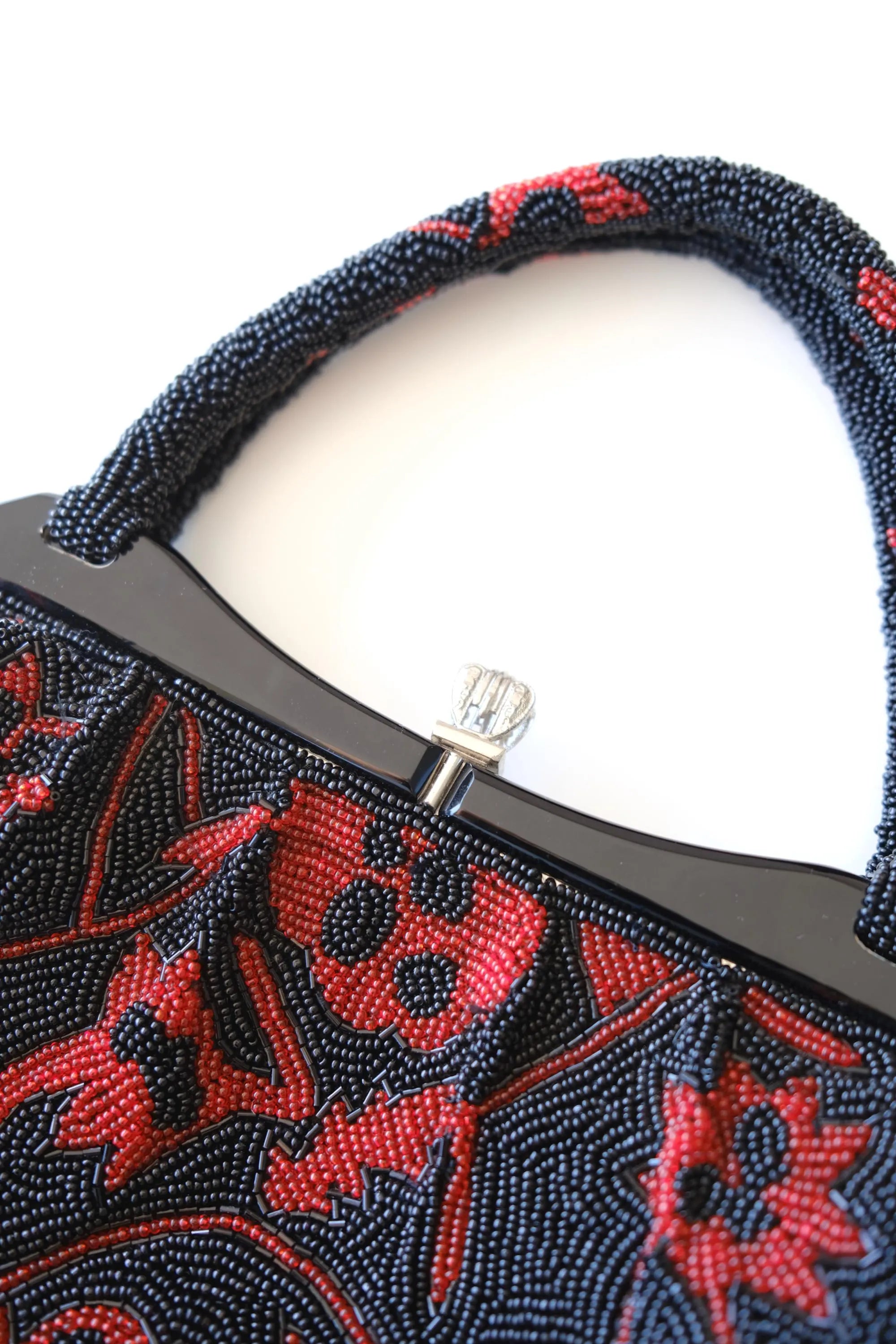 Close-up of decorative clasp closure and silver-tone metalwork on vintage Japanese beaded evening bag