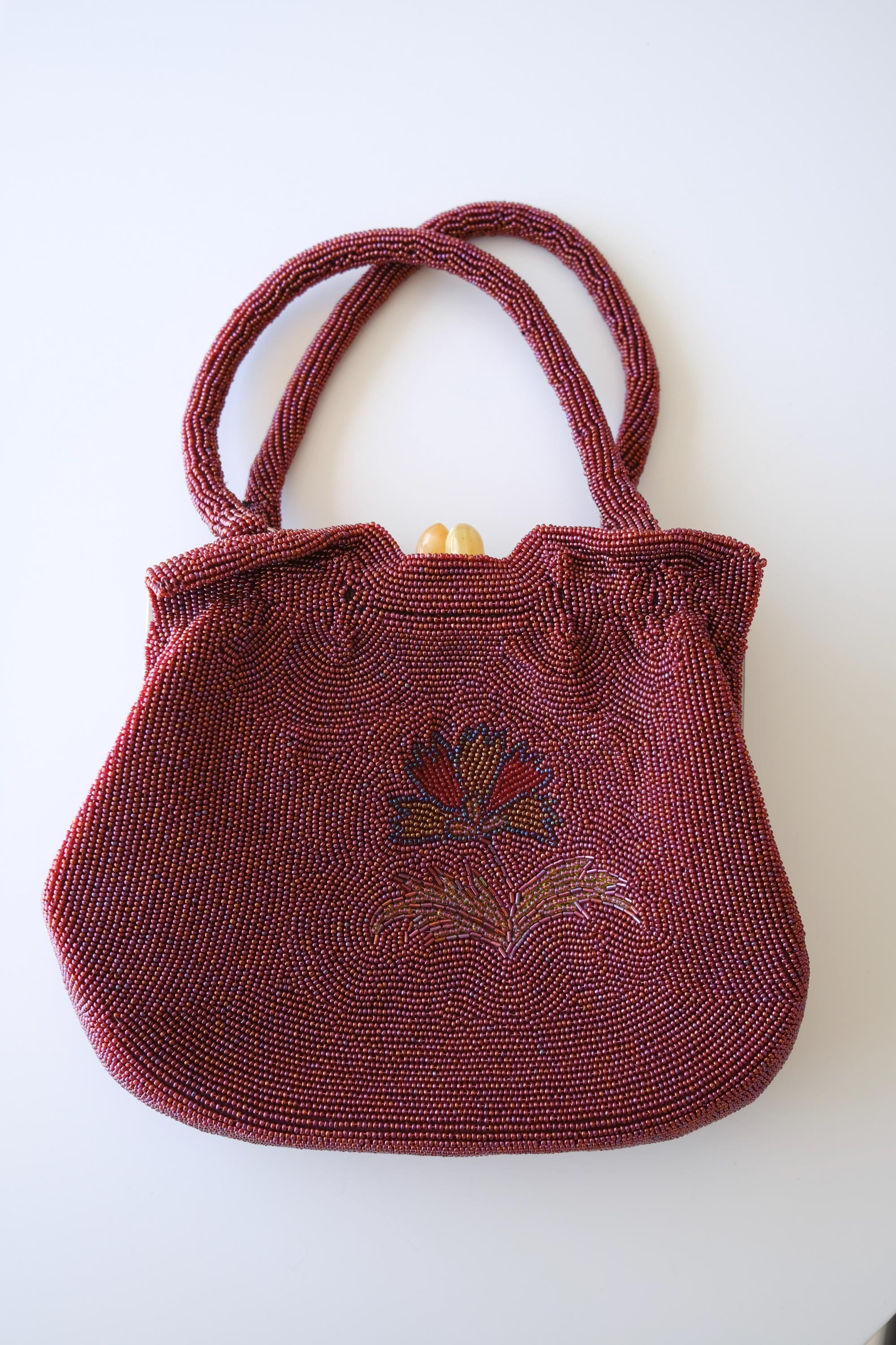 Vintage Japanese burgundy glass beaded handbag measuring approximately 23 cm wide, 31 cm high including handles and 5 cm deep