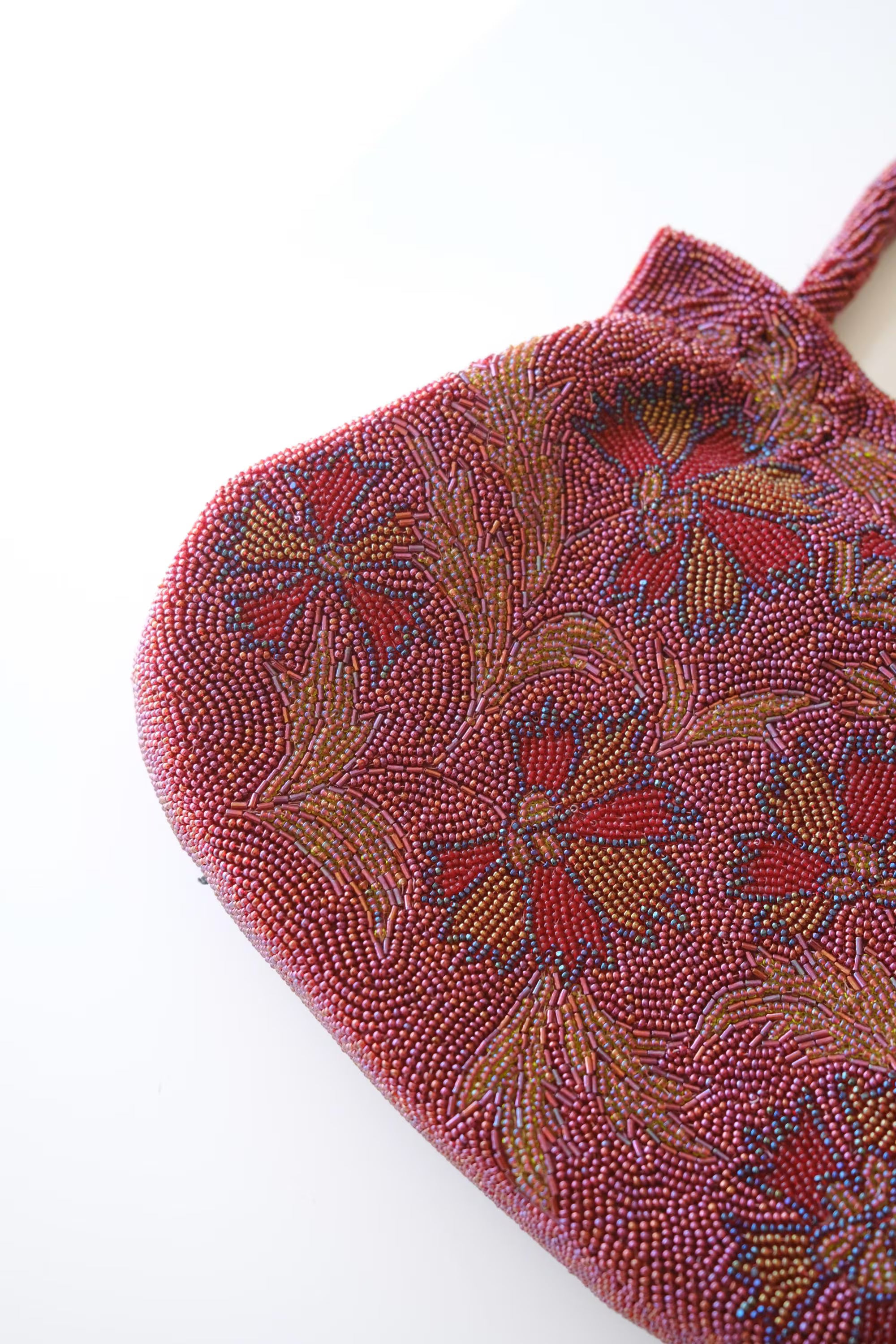 Close-up of intricate Japanese glass seed bead and bugle bead embroidery in burgundy, blue, gold and green