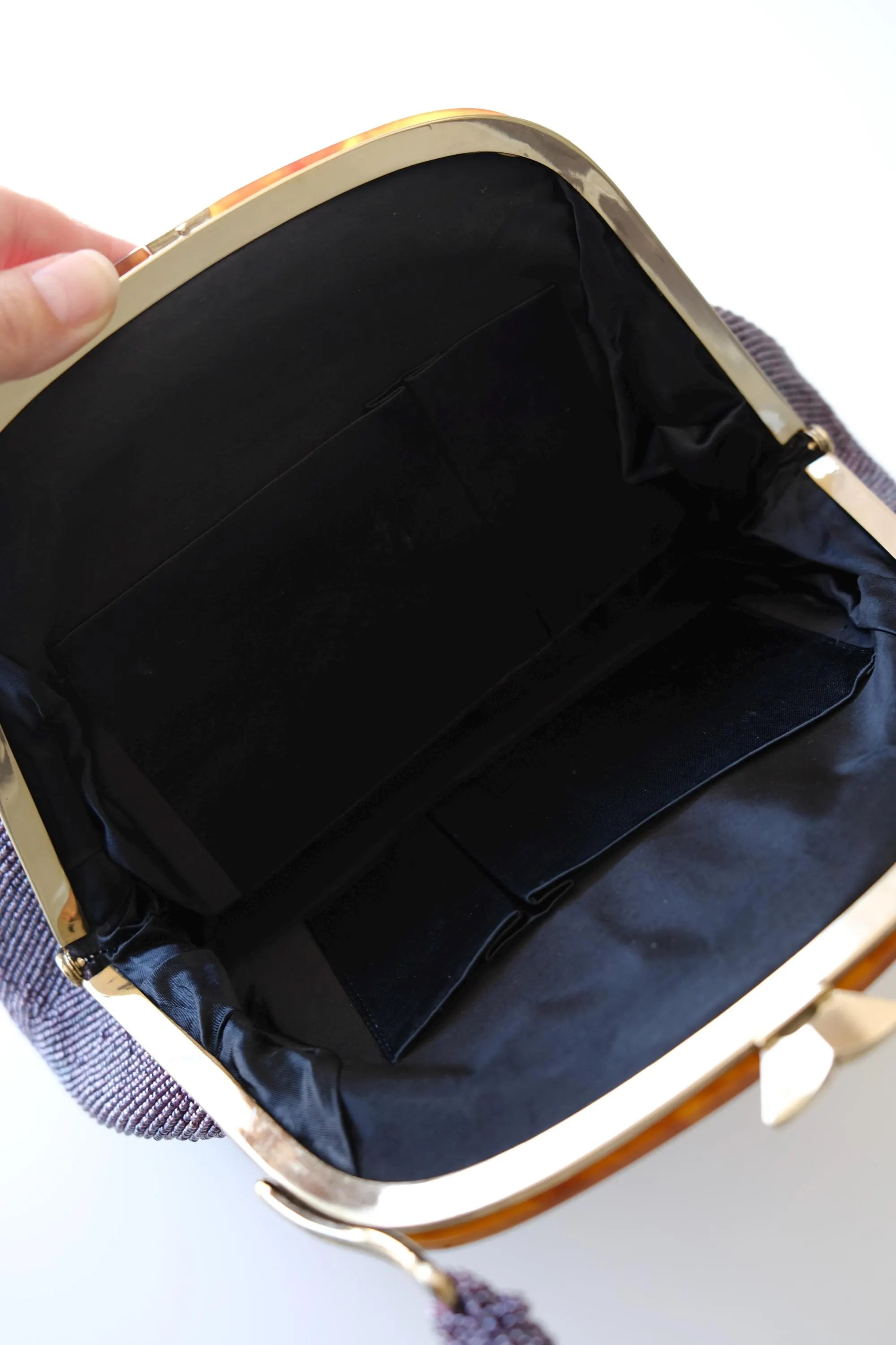 Interior view of vintage Japanese purple glass beaded handbag featuring black satin lining
