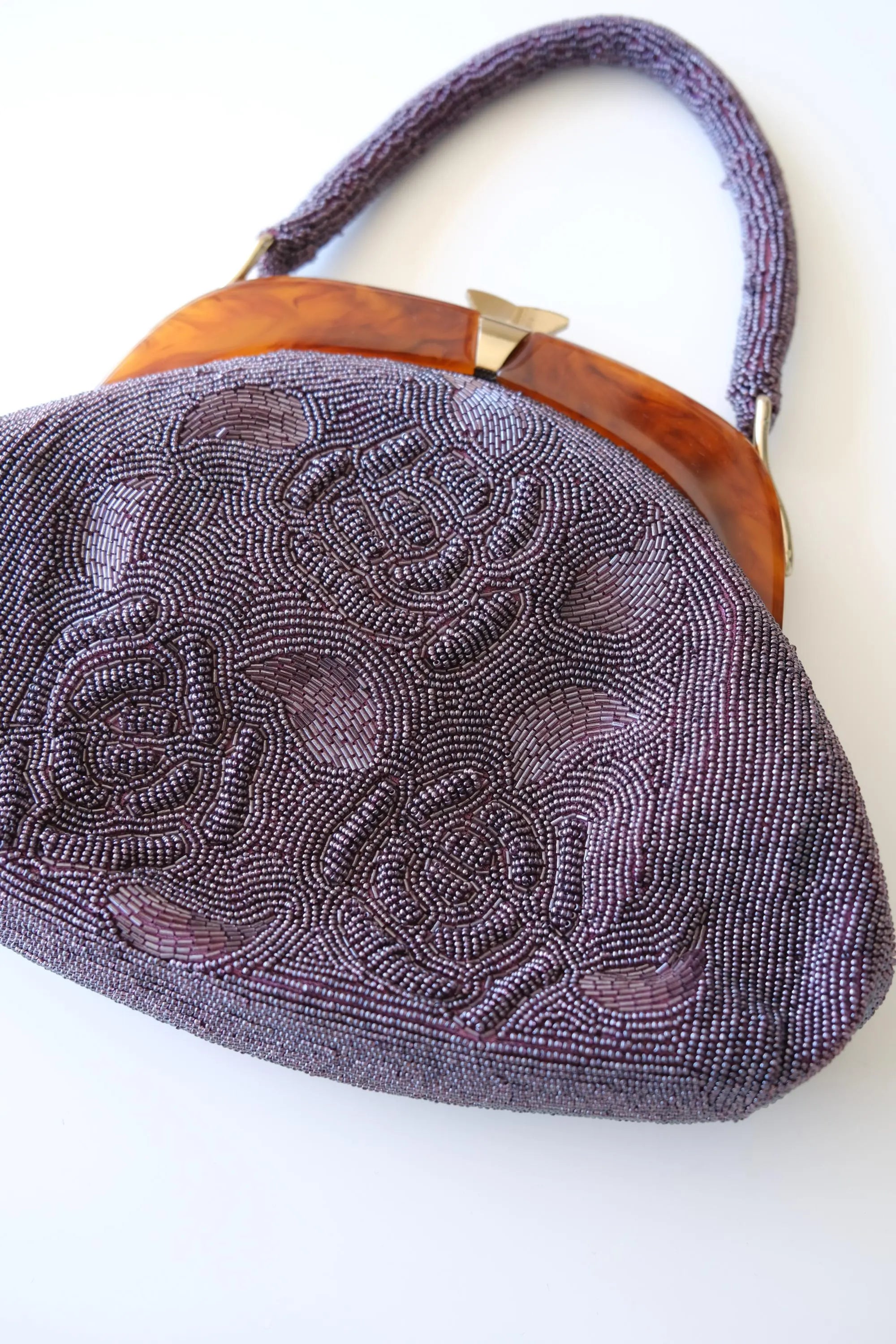Close-up of dimensional 3D rose floral embroidery made with tiny purple glass seed and bugle beads